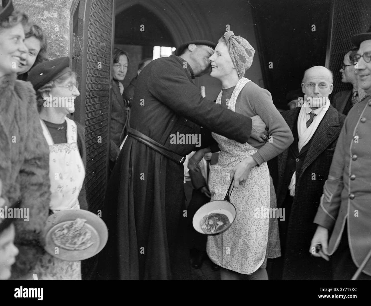 PANCAKE-RENNEN ENDET IN DER KIRCHE - - - - Hausfrauen des Dorfes Olney , Bucks , legen ihre Pfannen mit Pfannkuchen am Fuße des Kirchensteines nach dem 500 Jahre alten Pancake-Rennen, das heute nachgespielt wurde - Faschingsdienstag - Miss . KATHLEEN POWER . Das Rennen begann auf dem Olney Market, endete auf dem Church Market und endete in der Church, wo die Hausfrauen den Segen des Vikars erhielten. - - - - - 1. März 1949 Stockfoto