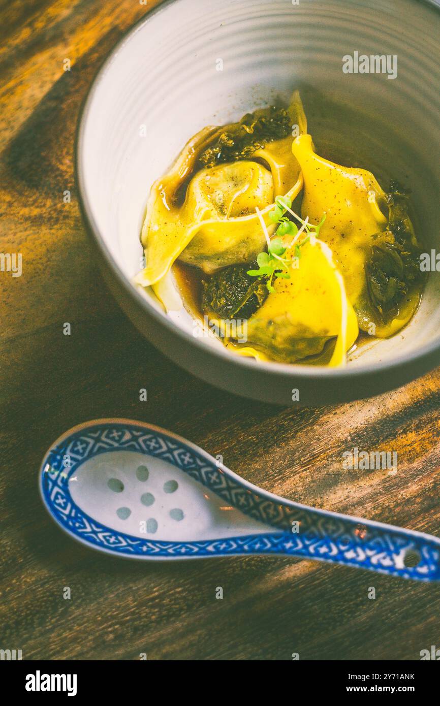 Gezogene Entenknödel mit Brodo, eingelegtem Grünkohl, wacholder-Kombu-Öl Stockfoto