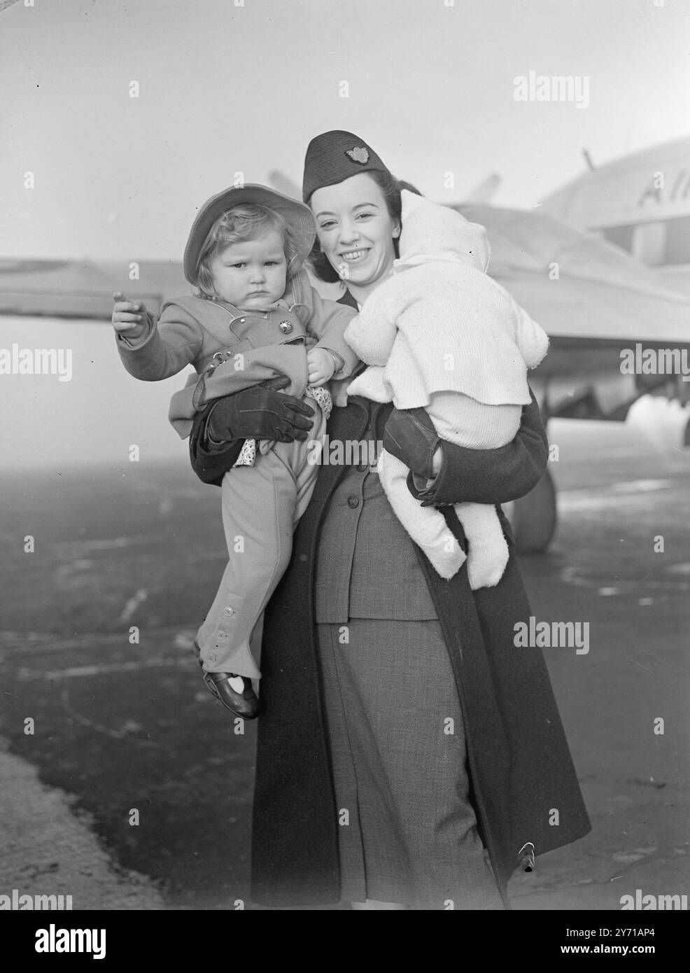 AIRMEN's FAMILIEN FLIEGEN NACH OSTEN eine weitere Reihe von Soldaten - Frauen und Kinder, die im Luxus Stil zu '' Troopship '' Raten '' fliegen, verließ Blackbushe Airport, Hants . Familien von Royal Air Force Personal sind im Rahmen des Regierungsprogramms in den Nahen Osten gegangen, um die Wiedervereinigung zu beschleunigen. DAS BILD ZEIGT: ES IST PAPA, DIE SIE WILL. Sheila Derwin ( mit gedrehtem Kopf ) ignoriert die Fotografen, da sie mit CAROL WEST von Air Hostess J an Bord genommen wird . WOODWARD in Blackbushe , für den Flug in den Nahen Osten . 16. Februar 1949 Stockfoto