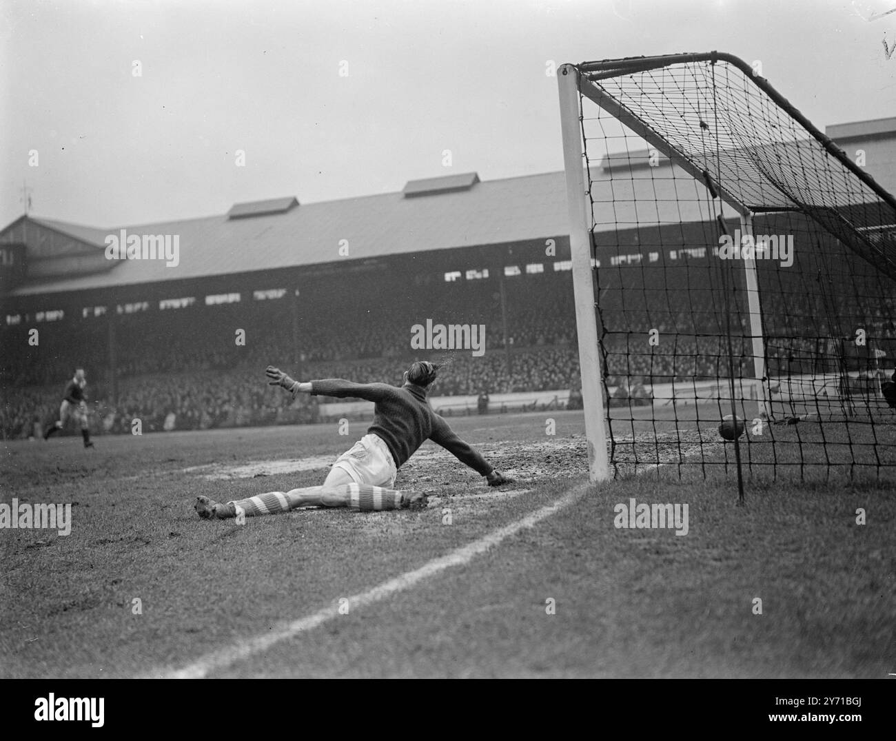 CHELSEA V BIRMINGHAM MERRICK , der Torhüter von Birmingham , liegt gestreckt in der Torhütte und beobachtet den Ball nach einem Schuss von CAMBELL , Chelsea außen rechts , ins Netz, um der Heimmannschaft ihr erstes Tor im Spiel zu geben . 1. Januar 1949 Stockfoto