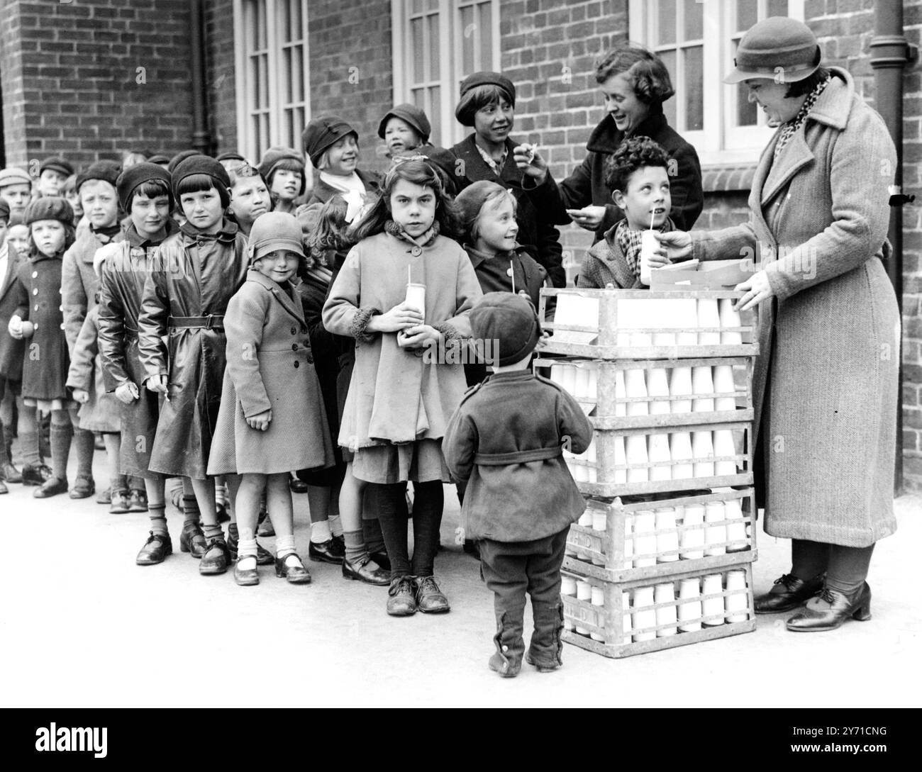 Eine Lektion, die sie mögen. Kinder gehen in den Ferien zur Schule, um Milch zu trinken. Obwohl die Schulen für die Feiertage geschlossen sind , erhalten die Schüler in Carshalton , Surrey , immer noch ihre tägliche Milch . Es wurde eine Regelung für die Abgabe von Milch an Kinder während der Ferien in Kraft gesetzt . Sechshundert Kinder besuchen drei Schulen im Bezirk für eine halbe Stunde morgens, um dort ihre Milch zu trinken. Die Milch wird durch einen halben Penny Beitrag des Kindes und einen halben Penny aus einem Zuschuss bezahlt . Freiwillige Frauen geben die Milch aus. Fotoshows, Carshalton Schoolch Stockfoto