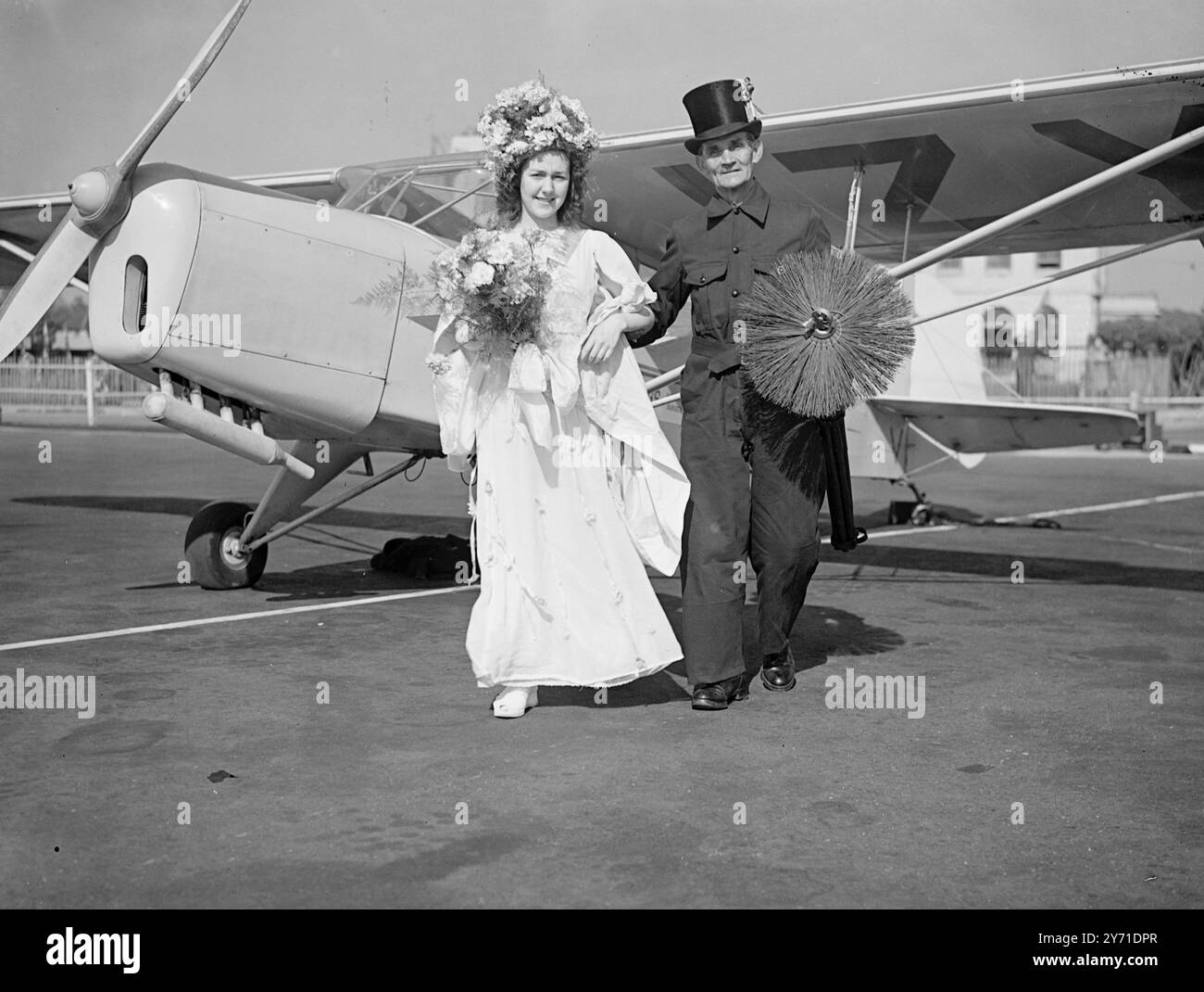 "KÖNIGIN MIT FLÜGELN" am FLUGHAFEN CROYDON - begleitet von ihren traditionellen Dienern - einem Schornsteinfeger - (Mr.W.S. KNIGHT). Von St. Leonards 14 Jahre alte ANN HILLS, May Queen of Hastings, kam heute von Hastings am Flughafen Croydon an. Die Königin, die unmittelbar nach ihrer Krönung durch den Bürgermeister von Hastings geflogen ist, wird an einer Sendung von B.C. teilnehmen, bevor sie nach Hastings zurückkehrt. - 8. Mai 1948 Stockfoto