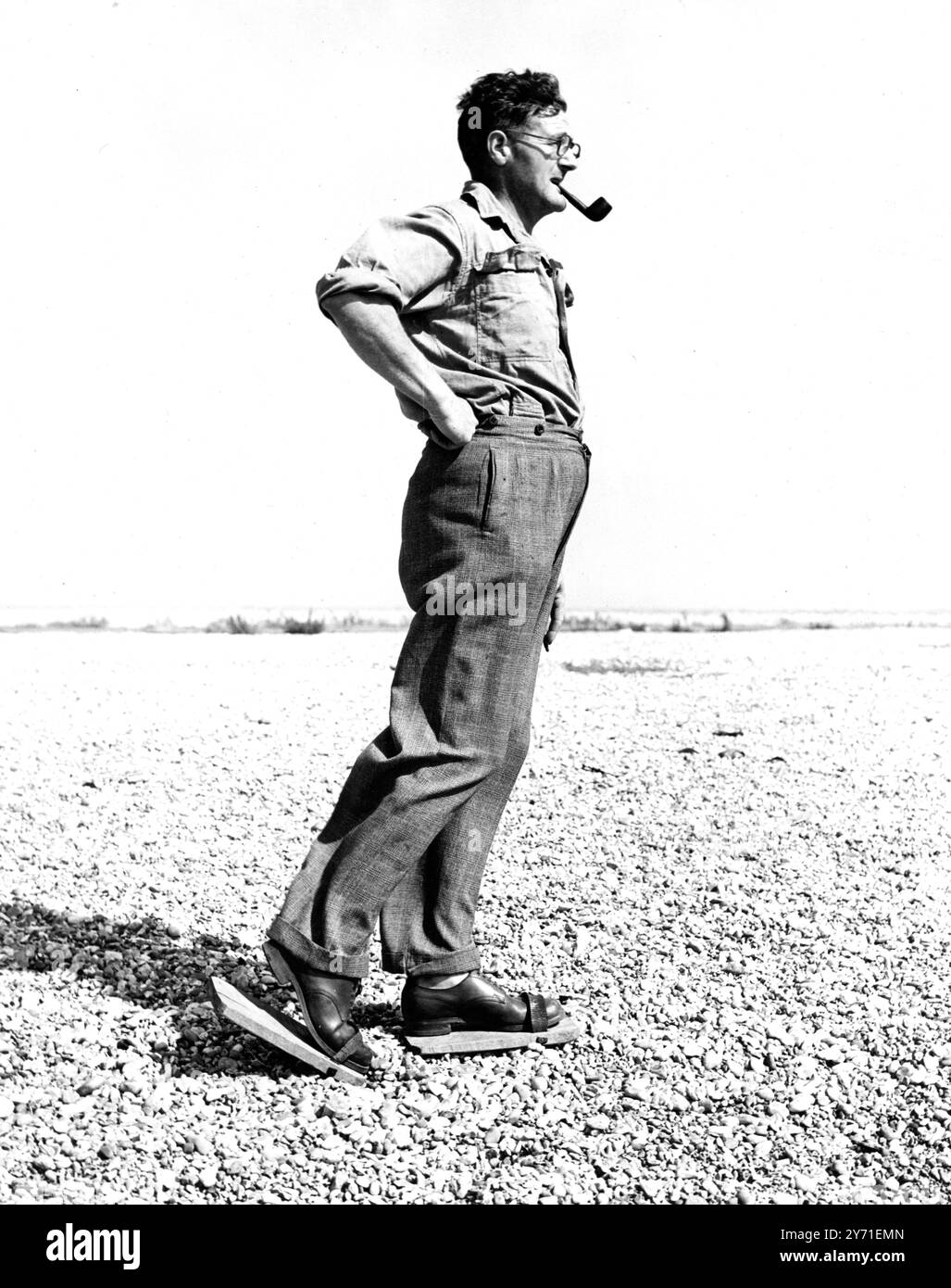 Mr. Mick Bates trägt "Backstay", wenn er am Strand von Dungeness spaziert. Sie ähneln Schneeschuhen, um ein Absinken des Trägers zu verhindern. Sidcup, Kent, 28. Juli 1949 Stockfoto
