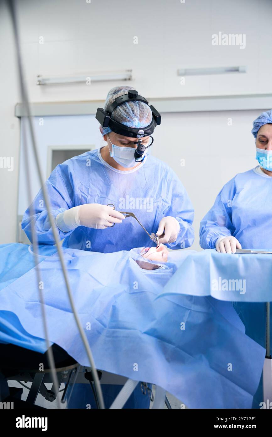 Der Chirurg führt eine Operation durch, um ein abgewandeltes Nasenseptum zu begradigen Stockfoto