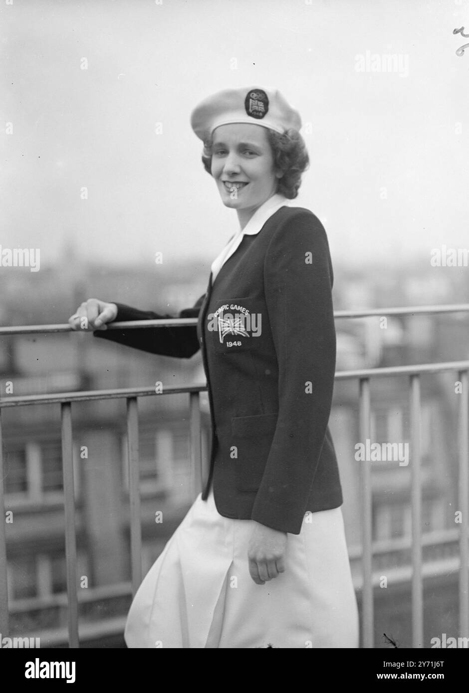 " OLYMPISCHE DESIGNS " BRITISCHE FRAUENUNIFORM GEWÄHLT . Simply Cut , White , offene Kleider mit eng anliegenden marineblauen Jacken , werden die Uniform der britischen Olympiateilnehmerinnen beim diesjährigen Spiel sein . Die Uniform wird von Mitgliedern des Teams aus einer Auswahl ausgewählt, die von einem Laden in der Oxford Street eingereicht wurde. Darüber hinaus wird die Baskenmütze mit dem Logo der union Jack Olympic Rings abgerundet. Der Saum des Rockes ist 15 cm vom Boden entfernt. DAS BILD ZEIGT: "Olympic Look " Ein lächelndes Modell zeigt heute die neue Olympiauniform der britischen Frauen in London. Mai 1948 Stockfoto