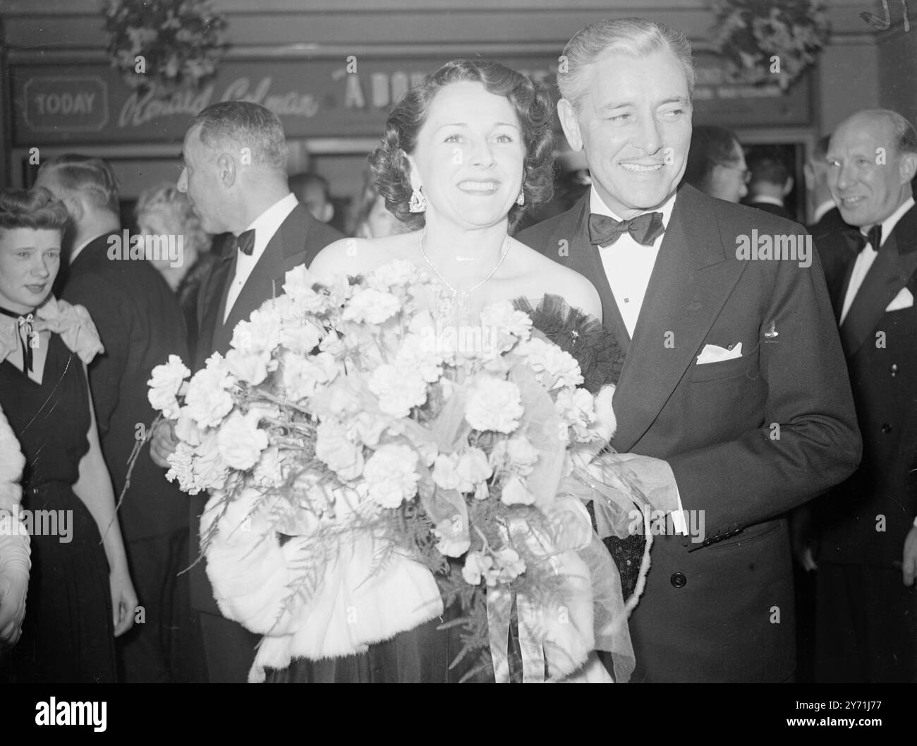 Die PREMIERE DES mit DEM OSCAR ausgezeichneten Films " A Double Life " ist Ein doppelter GEWINNER der LIFE ACADEMY Award . Heute Abend feierte er seine britische Premiere im Leicester Square Theatre in London und der gebürtige britische Star RONALD COLMAN kam nach 15 Jahren nach Hause, um an der Aufführung teilzunehmen. COLMAN, der einen Schauspieler spielt, der von seiner Rolle Othello besessen ist, gewann einen Oscar für seine Arbeit im Film. Er wurde von seiner Schauspielerin BENITA HUME begleitet. DAS BILD ZEIGT:- "Hausleben" Eine lächelnde MRS. COLMAN ( Benita Hume ) hält ihren Präsentationsstrauß, wie sie an diesem Abend mit Ehemann RONALD COLMAN abgebildet ist Stockfoto