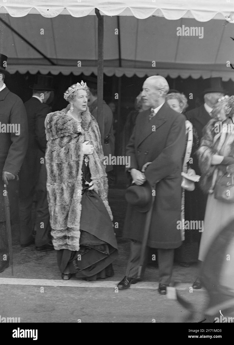 MARCHONESS OF LONDONDERRY UND LORD NEWALL BEI DER ERÖFFNUNG DES PARLAMENTS. Viele prominente Persönlichkeiten nahmen an der Parlamentseröffnung Teil, bei der zum ersten Mal seit 1938 eine vollständige Zeremonie stattfand. DAS BILD ZEIGT: Die MARCHIONESS OF LONDONDERRY und MARSHAL DER ROYAL AIR FORCE LORD NEWALL wartet auf ihre Autos vor den Häusern des Parlaments nach der Staatseröffnung . 26. Oktober 1948 Stockfoto