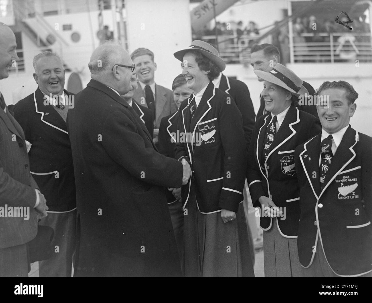 DIE ERSTE OLYMPIASIEGERIN AUS NEUSEELAND IST HIER . Das erste Team der Olympischen Spiele das dieses Land erreichte in Tilbury an Bord des M V ' PORT HOBART ' es gibt sechs Männer und eine Frau im Team die Neuseeland bei den Spielen vertreten werden , zu denen zwei Läufer , ein Hürdenläufer , ein Boxer , ein Radfahrer , ein Gewichtheber gehören . und ein Schwimmer. DAS BILD ZEIGT ;- die Rt . Hallo. W . J . JORDAN, Hochkommissar für Neuseeland, begrüßt Miss LANE, die einzige Frau, die in der neuseeländischen Mannschaft die Olympischen Spiele repräsentiert, bei der Ankunft in Tilbury Juni 1948 Stockfoto