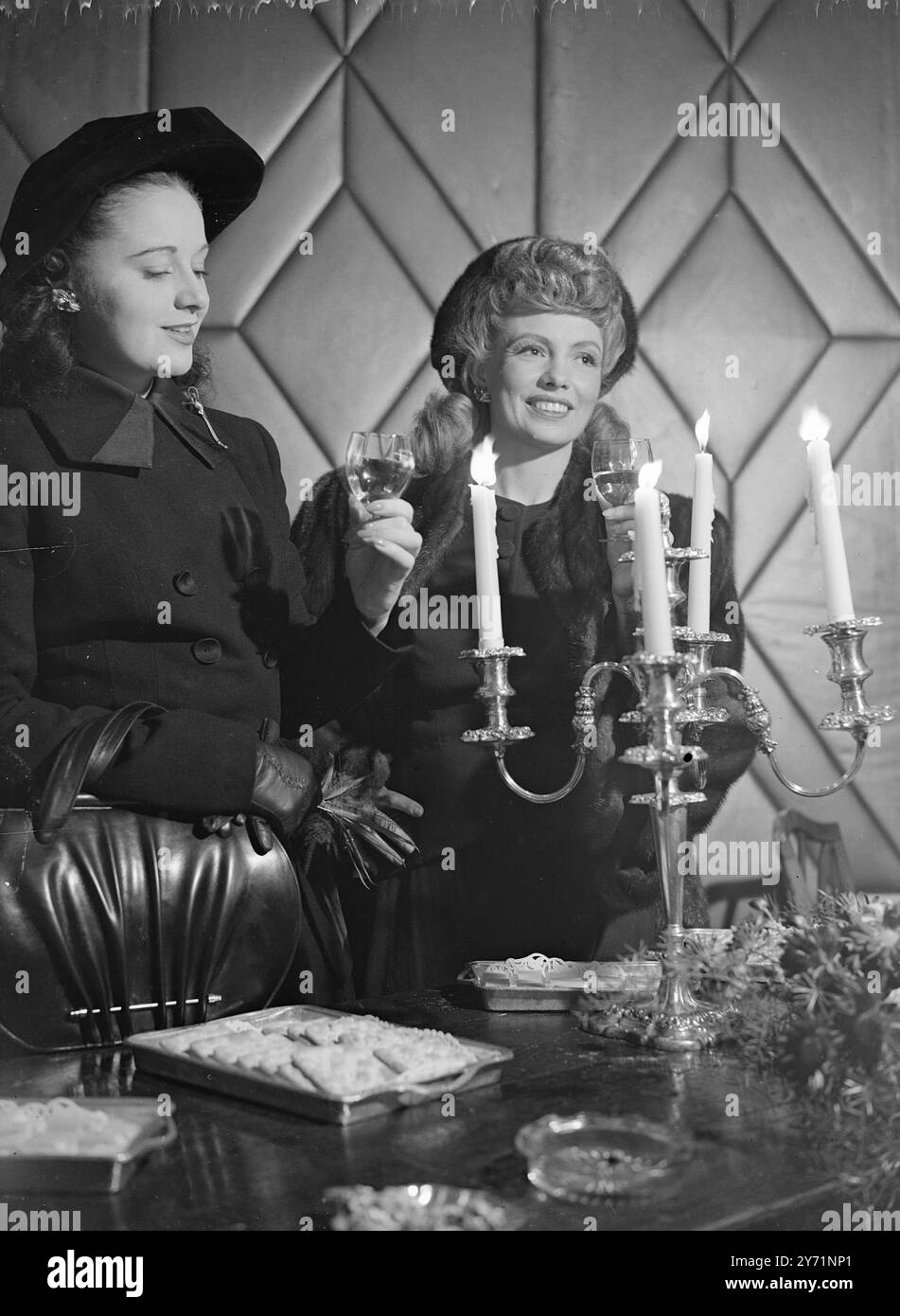 SCHAUSPIELERINNEN PROBIEREN WEINE AUS BORDEAUX BEI KERZENLICHT es ist ein alter Brauch AUS Bordeaux, alle gegossenen Weine bei Kerzenlicht zu probieren. Nun, es ist nur ein alter französischer Brauch. LIZBETH WEBB (links) von " Bless the Bride " und YOLANDI DONLAN (rechts) von " Cage Me A Peacock " halten den alten Brauch am Laufen, wenn eine besondere Weinprobe von Bordeaux-Weinen im Dorchester Hotel in London stattfand. 28. Oktober 1948 Stockfoto