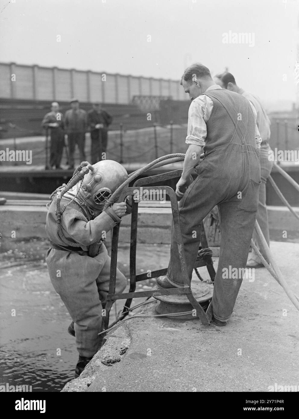 "The Right Hon. Diver" - M.P. geht unter. Es war ein Fall von " Vergessen Sie das Mitglied nicht " heute in den East India Docks, als Captain Ernest Marples, M. P ( Konservativer für Wallasey , Geschäftsführer einer Vertragsfirma ) trug einen Taucheranzug , um die Arbeit seines Unternehmens auf dem Boden der matschigen Themse zu untersuchen . Das Unternehmen baut das neue Kraftwerk von Papplar im Wert von 10.000.000 £ auf dem Gelände des Exportdocks in Ostindien und des Wharfs in Brunswick. Das Bild zeigt : - ' Lobbying Father Thames ' - Captain Ernest Marples , M.P. steigt heute in seinem Taucheranzug am East India Dock ab . Juni 1948 Stockfoto