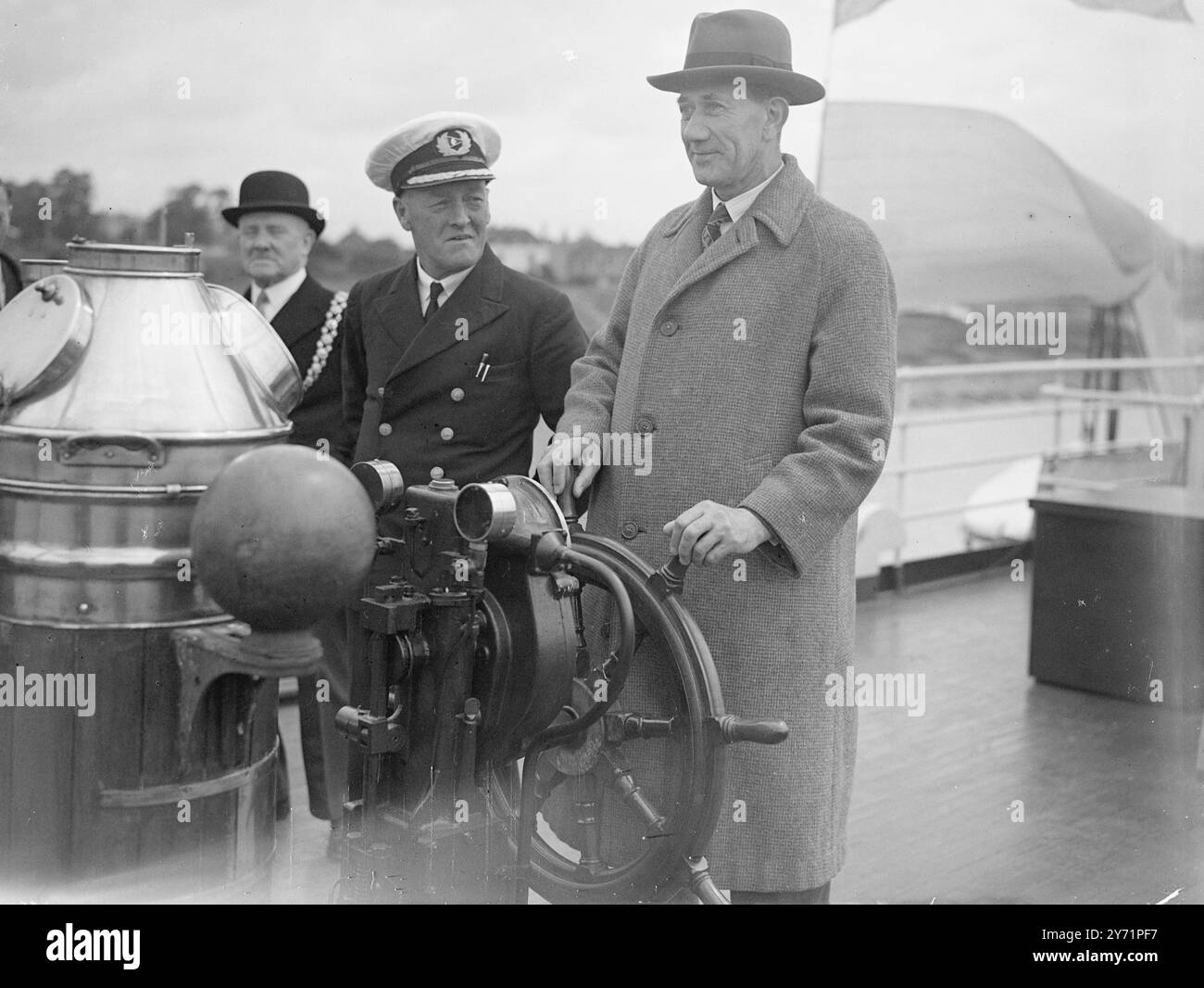 „M.P. am Rad“ - Bristol Docks feiert das hundertjährige Jubiläum. Die Bristol Docks feierten zum Gedenken an ihre 100 Jahre alte Stadtverwaltung und nahmen an dem Right Honor. Alfred Barnes, M.P., Minister für Verkehr Teil, der mit dem Vergnügungsdampfer "Bristol Queen" nach Avonmouth reiste. Das Bild zeigt: ' Ein Vergnügen für Ein Mitglied' - unter dem wachsamen Auge von Captain S. George, der Rt. Hallo Alfred Barnes, M.. P, nimmt das Steuer des Vergnügungsdampfers „Bristol Queen“ während ihrer Reise nach Avonmouth im Rahmen der Bristol Docks Feiern. Juli 1948 Stockfoto