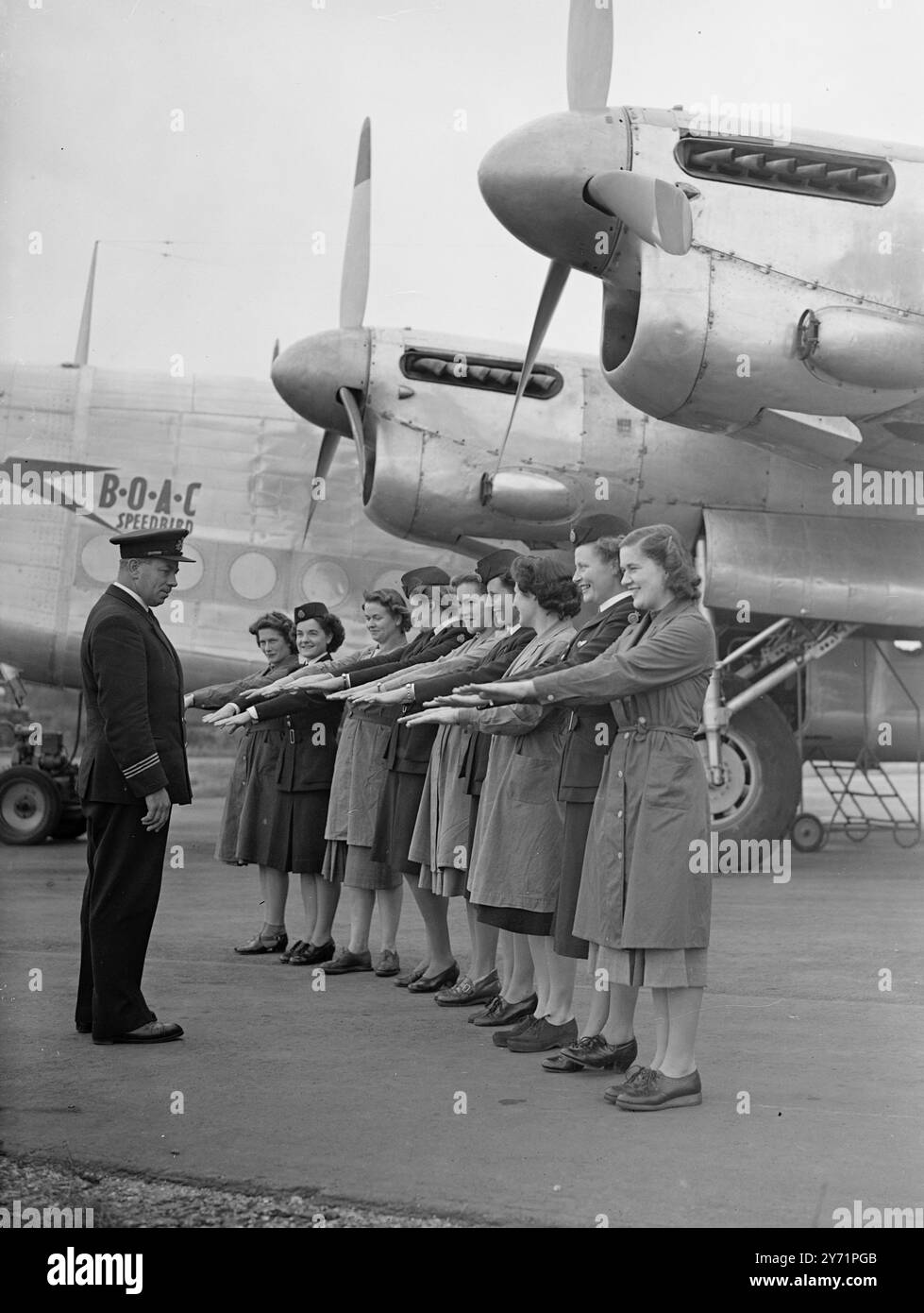 AIR STEWARDESSEN IN der HERSTELLUNG an der B.O.A.C. Staff Training School am Flughafen Hurn werden Mädchen in den Aufgaben einer B.O.A.C. Stewardess unterrichtet . In einem "Modell " einer Flugzeugkabine werden die Mädchen unterrichtet , wie sie am besten Lebensmittel mit Hilfe von Kühlschränken konservieren können , wie sie während des Fluges am Tisch servieren und wie sie andere Aufgaben einer Stewardess wahrnehmen können . DAS BILD ZEIGT:- Morgeninspektion- der Chefinstruktor gibt den Mädchen eine Inspektion, um sicherzustellen, dass der Hygienestandard eingehalten wird. Von rechts nach links sind: C. Robertson von Dunfermline, Stockfoto