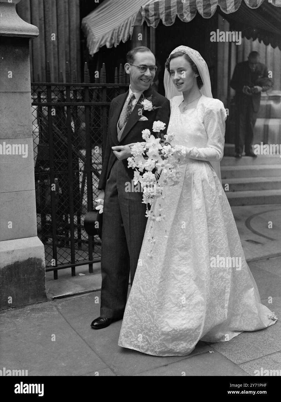"Romance im Außenministerium" Eine Freundschaft zwischen Miss Beryl Kimber und Mr. Charles martin Anderson begann im Außenministerium, wo sie beide arbeiteten, und hat sich zu Romantik entwickelt. Heute haben sie ihre Beziehung besiegelt, als sie St. James's Spanish Place in London zu ihrer Hochzeitszeremonie besuchten. Herr Anderson, der erster Sekretär ist, war bis vor kurzem Lord Pakenham Sekretär (heute Minister für Zivilluftfahrt). Das Bild zeigt: "Herzliche Beziehungen" - Mr. Anderson mit seiner Braut verlässt St. James's nach ihrer Hochzeitszeremonie. Stockfoto
