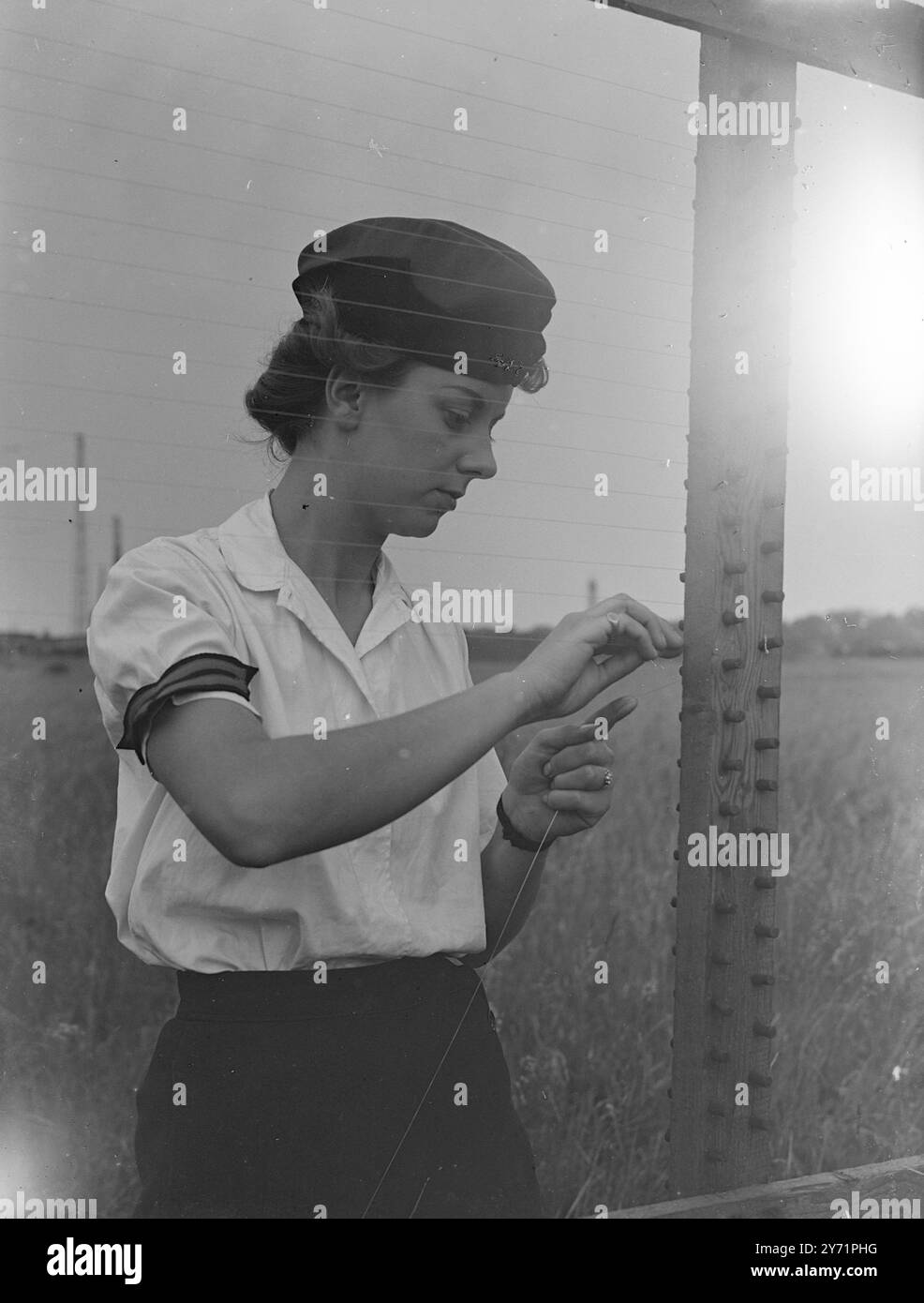 "Cordite Sisters" in Gunnery Establishments, Shoeburyness. 30 A.T.S.-Mädchen leisten einen einzigartigen und gefährlichen Job in der Experimental Gunnery Establishment, Shoeburyness, Essex. Sie müssen mit 1.000 Metern schweren Granaten stehen, um die Genauigkeit der Schießzeiten auf eine hundertstel Sekunde zu erfassen. Während ein 25-Pfünder seine Schale jammert durch die Luft schickt, schauen die Mädchen durch Teleskoplinsen und zeichnen mit Hilfe von Instrumenten einen Graphen-Messwert auf einer Karte. Um sie im Sortiment auffällig zu machen, tragen sie blaue Uniformen mit weißen Blusen. Das Bild zeigt: „Hinter dem W Stockfoto