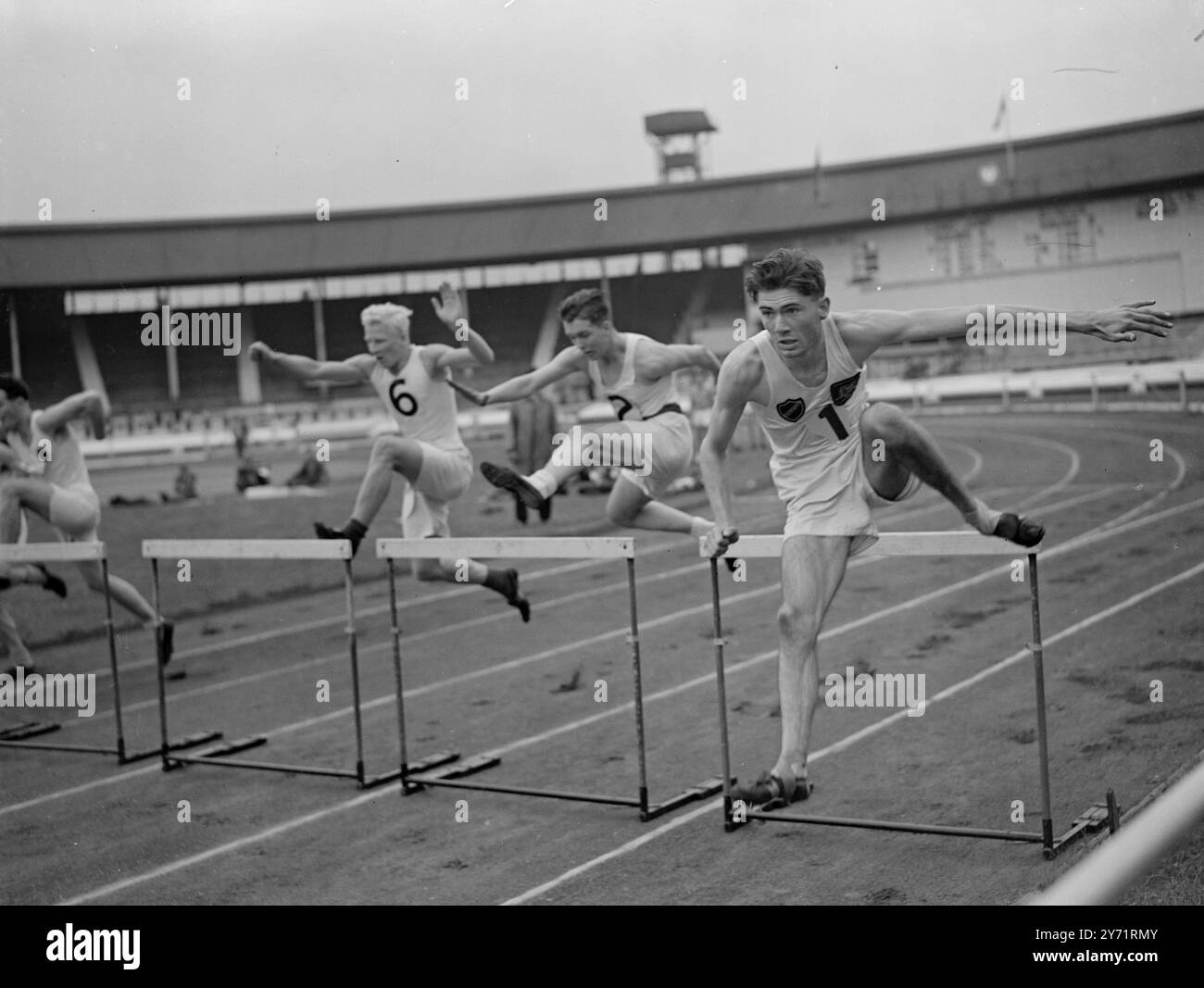 „Sieger geht über“ J Birrell (rechts), 18-jähriger Barrow Boy, der für die 110 Meter bei den Olympischen Spielen ausgewählt wurde, nimmt die Hürde mit gutem Stil und gewinnt die 1. Hitze der 120-Yard-Hürden bei den Amateur Athletic Junior Championships in der White City. Juli 1948 Stockfoto