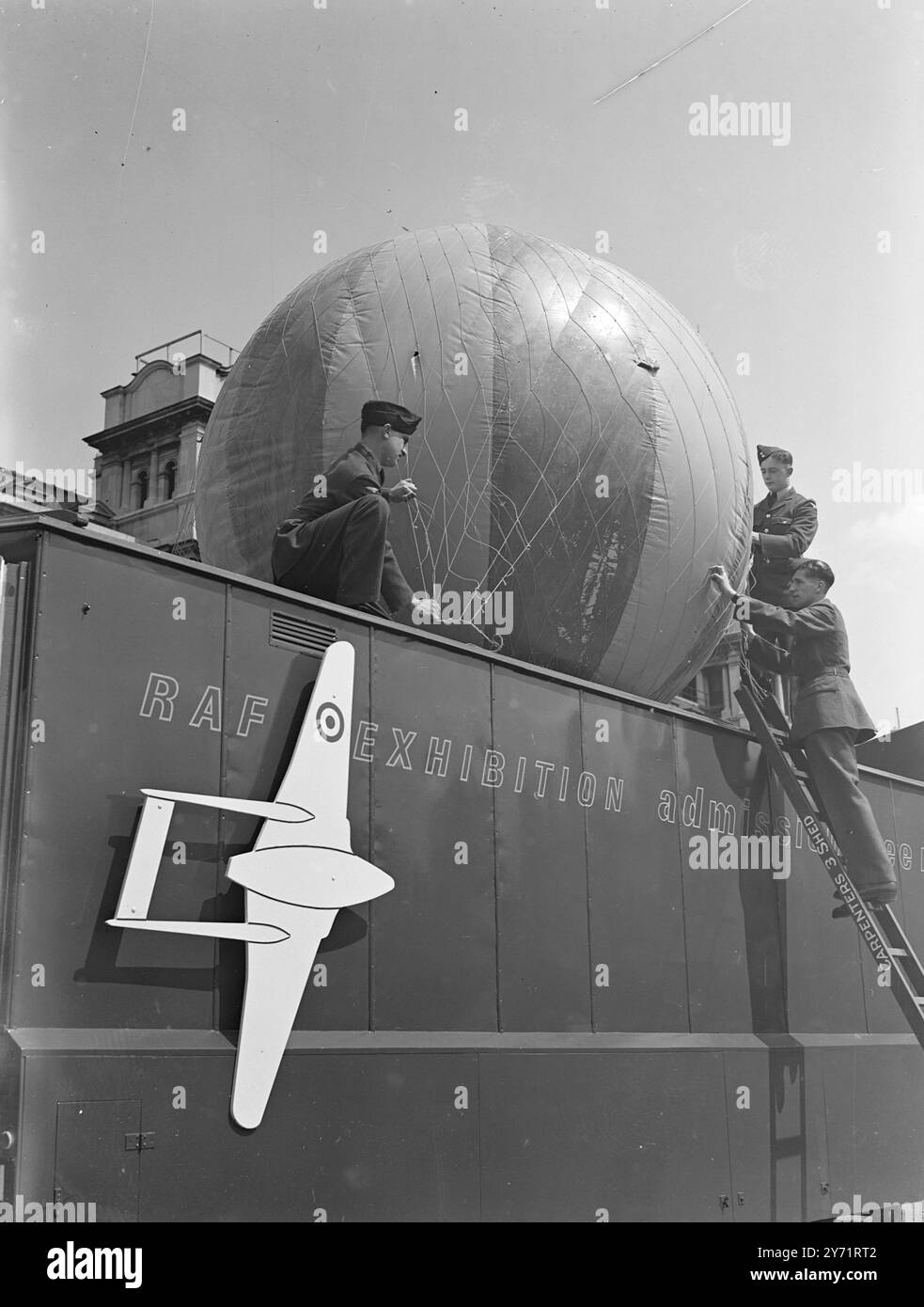 Man Takes Wings – RAF Mobile Exhibition man Takes Wings wurde von dem Secretary of State for Air, dem RT Hon. Arthur Henderson, K.C., Abgeordneter , auf der Horse Guards Parade in London eröffnet . Die Ausstellung zeichnet anhand von Fotografien und Arbeitsmodellen die Entwicklung des Fluges vom Ballon zum Jet-Flugzeug nach . Es ist die erste von ähnlichen Ausstellungen, die das Land bereisen werden. Das Bild zeigt " der Ballon geht nach oben " Ein halbmaßstäblicher Modellballon ähnlich dem, der die erste authentifizierte Luftfahrt gemacht hat, wird auf das Dach der Ausstellung in Hor gehisst Stockfoto