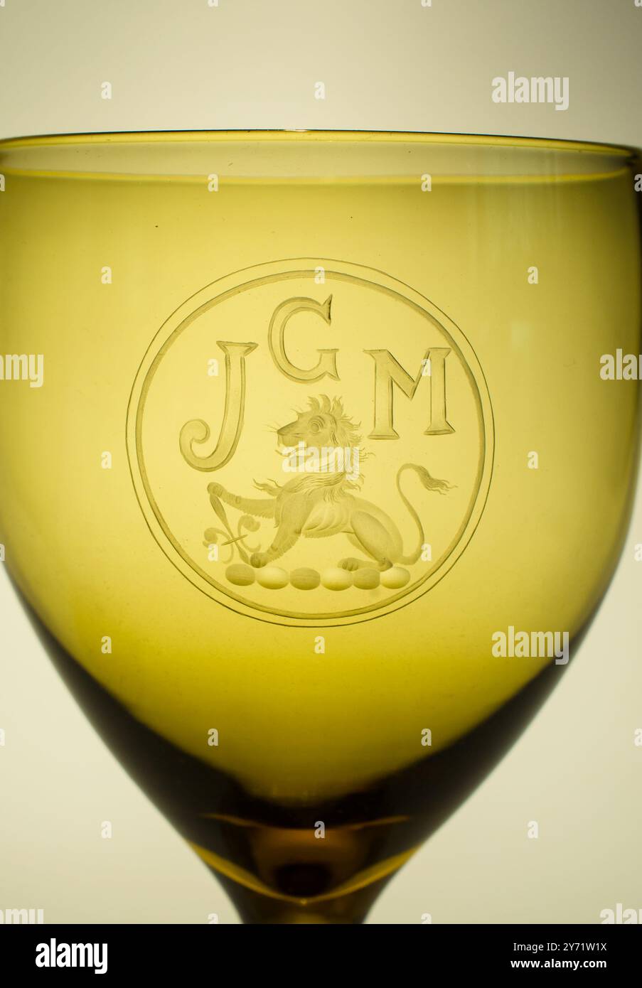 Spätviktorianisches Weinglas in dunklem Bernstein mit hervorragendem Kupferrad mit Monogramm und Lion Crest - handmundgeblasene Handwerkskunst Stockfoto