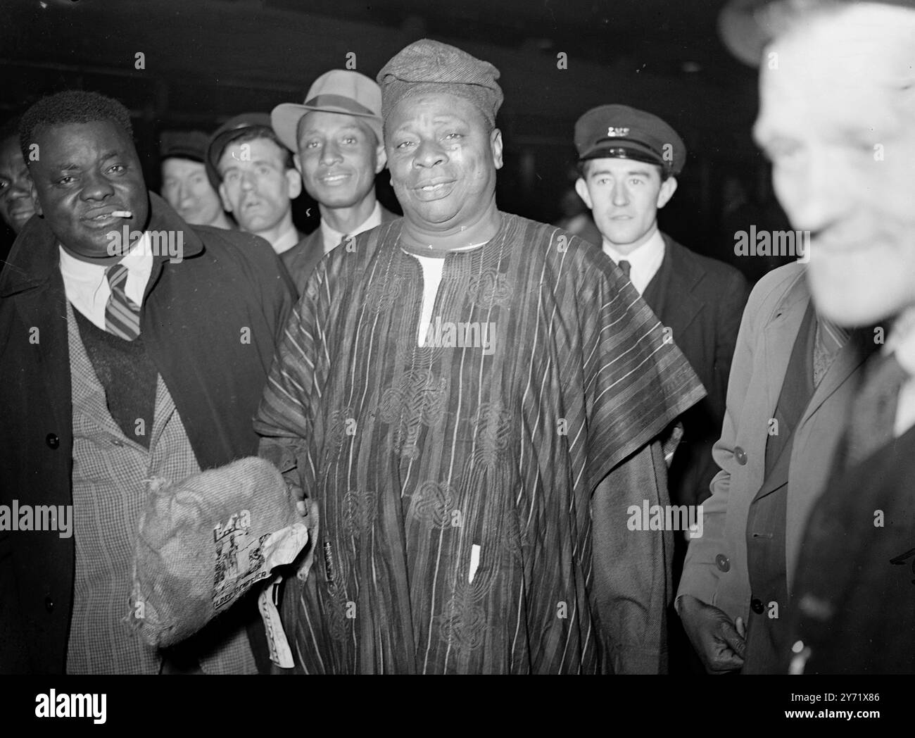 Afrikaner kommen zu Londoner Gesprächen. Fast 40 Delegierte der afrikanischen Konferenz, die am Mittwoch im Lancaster House in London eröffnet wird, kamen heute in Liverpool im Liner Apapa an. Sie kamen in bunten Gewändern und Insignien an Land. Viele haben ihre Frauen mitgebracht. Sie werden zwei Monate in Großbritannien bleiben. Auf der Konferenz, die von Herrn Herbert Morrison (Lord President of the Council) eröffnet wird, werden die Delegierten die lokale Regierung, die Öffentlichkeitsarbeit, die medizinische Politik, die landwirtschaftliche Entwicklung, die anhaltenden wirtschaftlichen Probleme und die Mittel der wirtschaftlichen Entwicklung erörtern. Das Bild zeigt: Obisesan, einer der DE Stockfoto