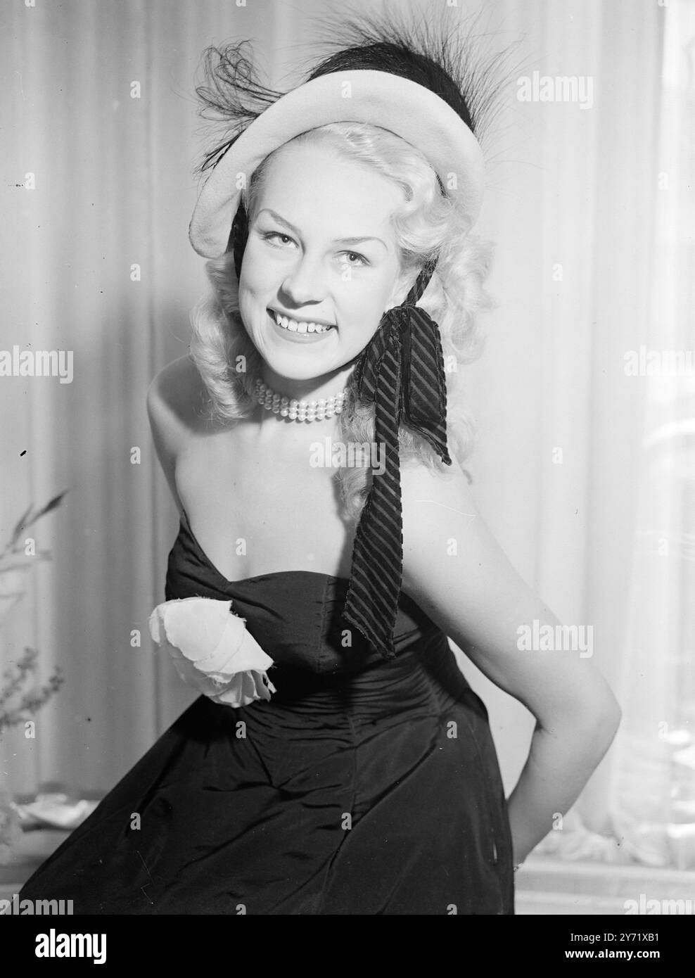 Cocktail Party hat eine pastellrosa Baskenmütze mit schwarzem Samt und einer Asprey-Feder-Vorderseite, getragen von Miss Patti Morgan, der australischen Filmstar und Schönheitskönigin bei London Fashion Display. August 1948 Stockfoto