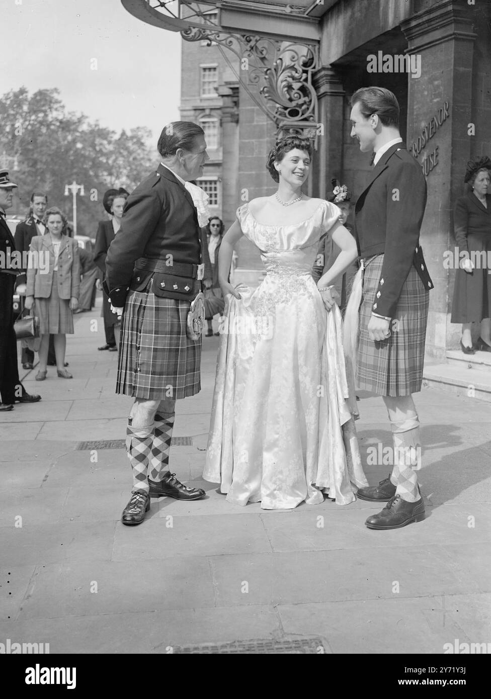 PROBE DER HERREN-MODESCHAU Eine Probe der Herren-Modeschau, die vom 20 . bis 24 . September stattfindet , fand im Grosvenor House in London statt , organisiert von der National Federation of Merchant Tailors , es wird eine Modeschau mit dem Unterschied sein . Es wurde als Theaterstück von einem Team von Autoren-Produzenten entworfen, die mit Ted Kavanagh, dem ITMA-berühmten ITMA, verbunden sind. Die Besetzung besteht aus zwölf Männern und fünf Frauen. DAS BILD ZEIGT: Drei der Spieler der Herrenbühnen-Modenschau, die eine Probe im Grosvenor House in London besucht haben. Sie sind nach rechts, Richard Neller, trägt alte Fashios Stockfoto