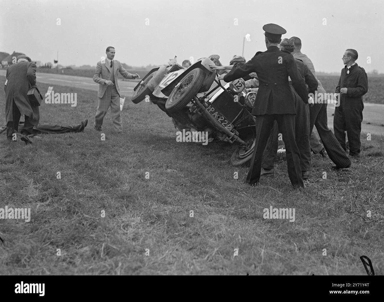 Viele der berühmtesten britischen Rennfahrer , darunter drei Frauen , nahmen am ersten Goodwood Motor Racing Meeting Teil . Hauptereignis auf dem Programm war das Goodwood Trophy Race für den Grand Prix One Half-Liter-Wagen. Das Treffen wurde vom Junior Car Club organisiert und organisiert. DAS BILD ZEIGT:- der Veteranenrennfahrer JOE LOWREY erhält erste Hilfe, nachdem er auf die Seite der Strecke geschleudert wurde, als sein H.R.G.-Rennfahrer im zweiten Rennen mit fast 60 km/h unterwegs war . September 1948 Stockfoto
