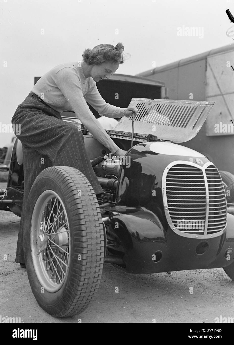 Viele der berühmtesten britischen Rennfahrer , darunter drei Frauen , nahmen am ersten Goodwood Motor Racing Meeting Teil . Hauptereignis auf dem Programm war das Goodwood Trophy Race für den Grand Prix One Half-Liter-Wagen. Das Treffen wurde vom Junior Car Club organisiert und organisiert. DAS BILD ZEIGT:-Miss. DAPHNE WALLIS , Champion Ice Dancer von 1937-1947 und jetzt Mechaniker für ihren Mann , erwärmt den Motor des Maserati vor einem Rennen . September 1948 18. September 1948 Stockfoto