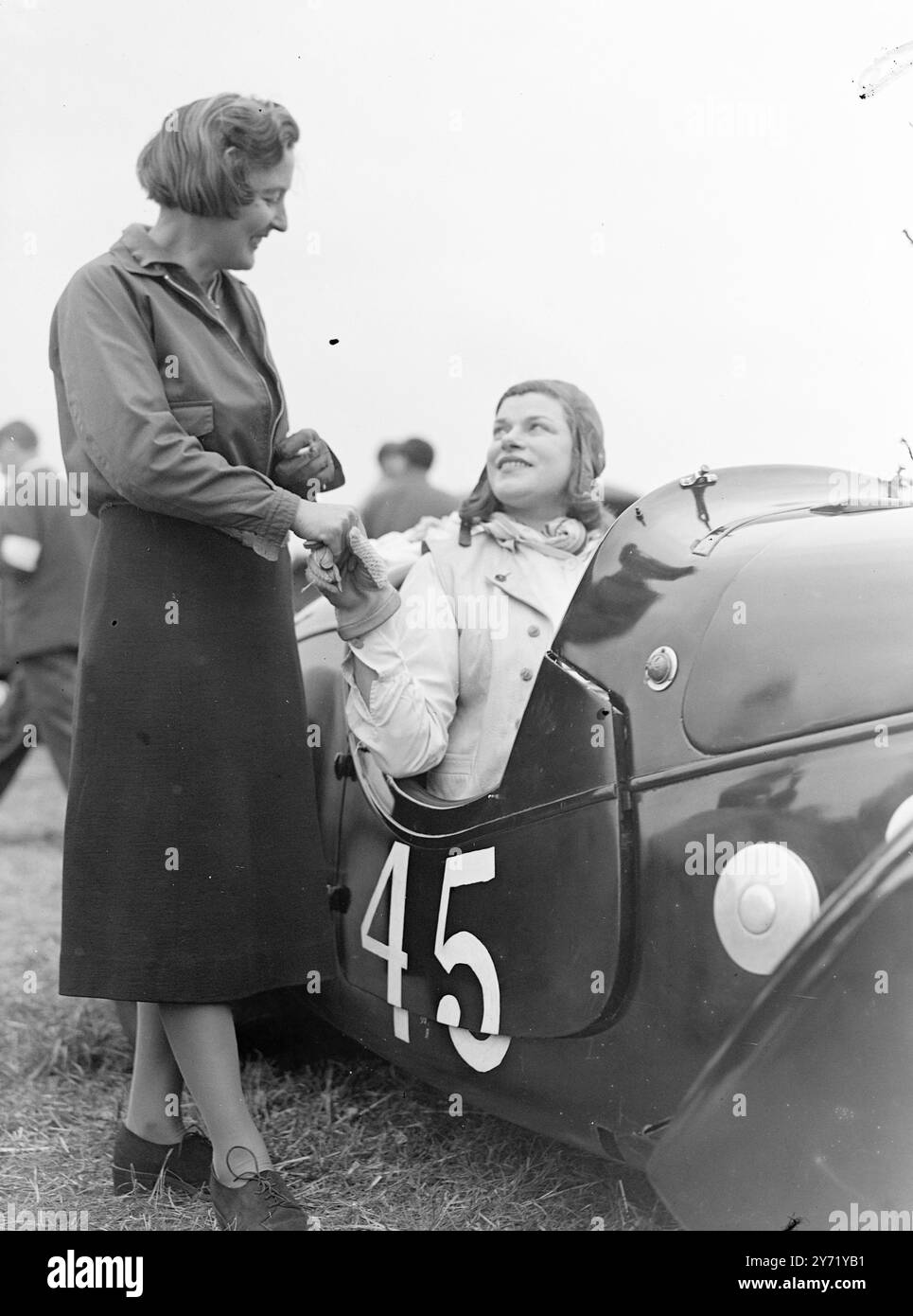 Viele der berühmtesten britischen Rennfahrer , darunter drei Frauen , nahmen am ersten Goodwood Motor Racing Meeting Teil . Hauptereignis auf dem Programm war das Goodwood Trophy Race für den Grand Prix One Half-Liter-Wagen. Das Treffen wurde vom Junior Car Club organisiert und organisiert. DAS BILD ZEIGT: Miss Betty Haig, Nichte von Earl Haig, der berühmte General, wünscht Miss Dorothy Patten viel Glück vor ihrem Rennen in ihrem Peugeot . September 1948 Stockfoto