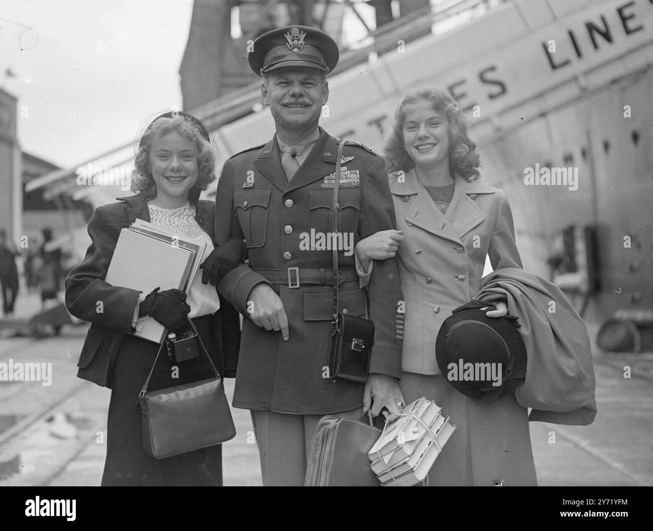 DIE TÖCHTER DES GENERALS KOMMEN AN, als das Schiff der United States Lines " America " in Southampton an Bord zwei amerikanische Mädchen anlegte . Eine ist vierzehn und die anderen fünfzehn , und sie sind die Töchter von General Leon Johnson , dem Kommandeur der dritten Luftdivision der Vereinigten Staaten . Sie kamen mit ihrer Mutter aus New York und wurden bei ihrer Ankunft von ihrem Vater empfangen. Die Mädchen werden eine Schule in London besuchen. DAS BILD ZEIGT :- General Johnson mit seinen Töchtern SUE ( links ) und SALLY nach der Ankunft des Mädchens . September 1948 Stockfoto