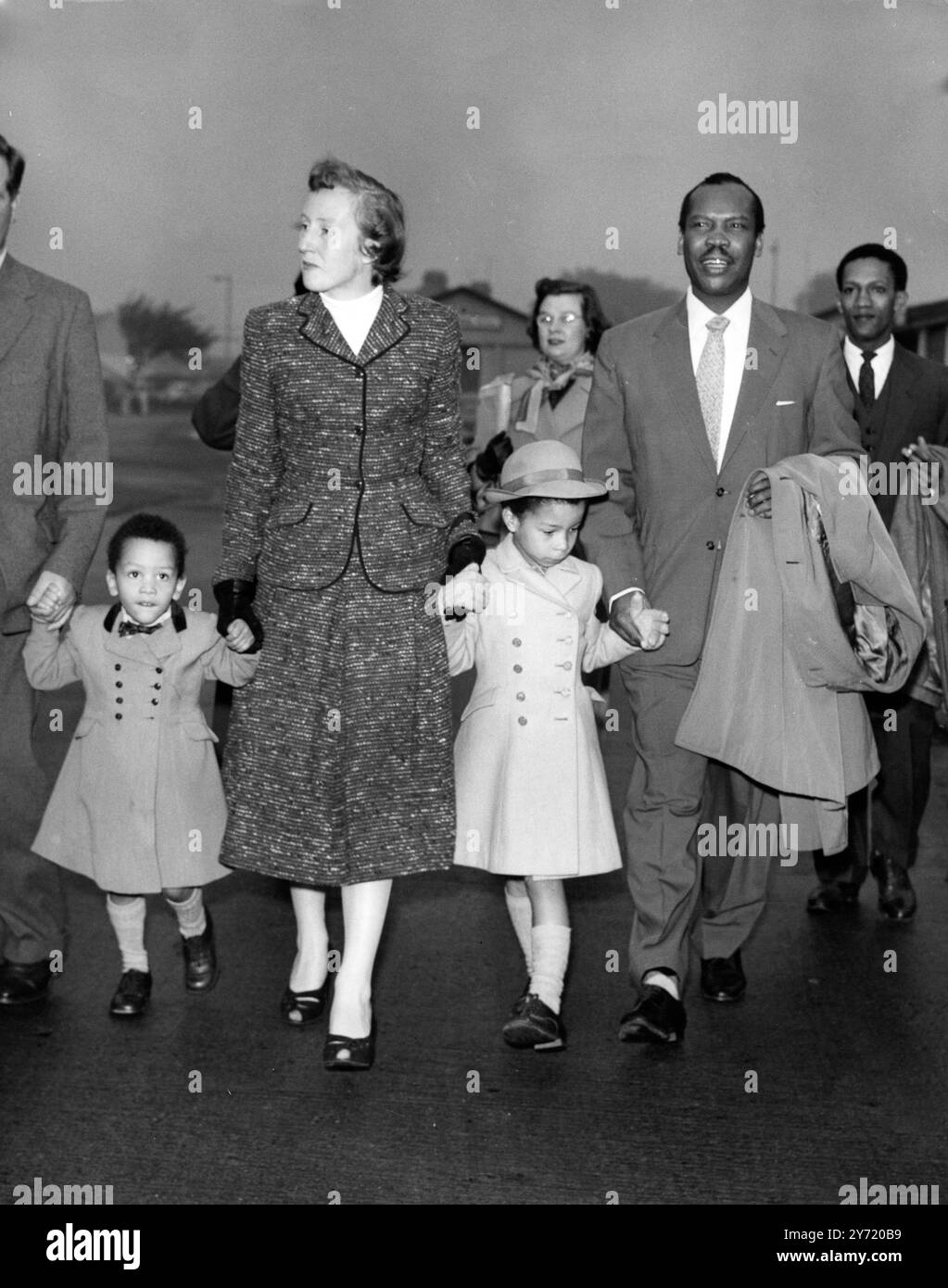 Seretse Khama auf dem Heimweg. Seretse Khama, der ehemalige Cheif des Bamangwato-Stammes, kommt heute mit seiner Frau Ruth und den Kindern Jacqueline und Ian am Flughafen London an. Er war auf dem Weg zurück nach Bechuanaland, nachdem er seinen Anspruch auf das Häuptlingsamt aufgegeben hatte, am Ende seines Exils begann er 1950, als seine Ehe mit Ruth Williams eine Spaltung seines Stammes verursachte. Sein Flug vom London Airport nach Salisbury, Südrhodesien, wurde heute durch Nebel verzögert. Seine Frau und seine Kinder werden Ende des Monats in Serowe sein. 9. Oktober 1956 Stockfoto