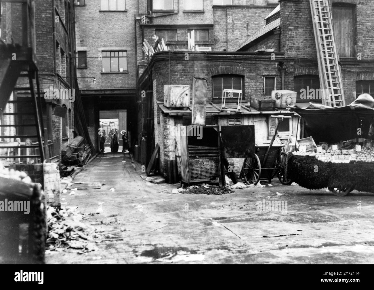 Das war Rubber Bones' Londoner Heimat. London: Der Hof an der Oxford Street in London, ein beliebtes Einkaufszentrum im West End, wo Harold ' Rubber Bones ' Webb, der entflohene Dartmoor-Gefangene, entdeckt wurde. In der Mitte ist der Herd zu sehen, über dem er seine Speisen kochte, und daneben der Wagen, unter dem er schlief. Der Hof war sein Zuhause für zwei Nächte. Durch den Torbogen ist die Oxford Street. Webb entkam aus Dartmoor, als er einen Heißluftschacht hinuntersprang, über die Gefängnismauer klammerte und einen Zug nach London sprang. Er war für eine Woche frei. Als er vom Hof genommen wurde - Wi Stockfoto