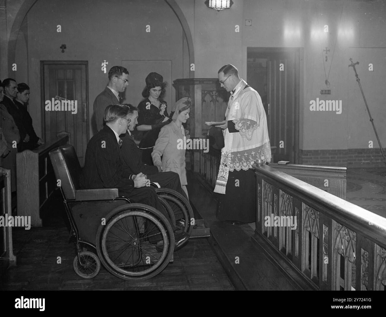 Hochzeit Mit Rollstuhl. Rollstühle wurden von der Ehrengarde des Mitpatienten benutzt, als Ex-Coldstream-Garde, Sgt, George Swindlehurst, der in Deutschland verwundet wurde, Schwester Winifred Doyle in der römisch-katholischen Kirche St. Edwards, Macclesfield, Cheshire heiratete. Die Braut besuchte Sgt Swindlehurst, als er Patient im Warrington Military Hospital war. Pater Coyne führt die Zeremonie zwischen Sgt Swindlehurst und Miss Doyle in St. Edwards durch. Bill Shiel (nächste Kamera) war der „beste Mann“ in einem Rollstuhl wie der Bräutigam. - - 7. März 1948. Stockfoto