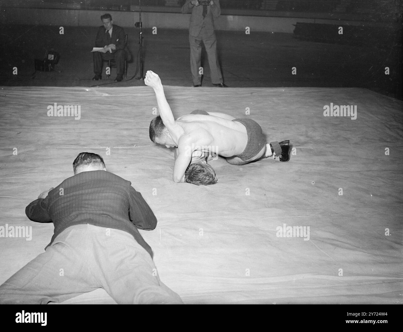 Wrestler aus ganz Großbritannien waren heute (Dienstag) in der Harringay Arena im Einsatz, als die British Amateur Wrestling Association die British Championships und Olympia Trials ausführte. Das Bild zeigt:Ansicht des Schiedsrichters. Ich will das Fairplay im Kampf zwischen L. sehen Dimmock (London) - er ist oben - und R. Myland, ebenfalls aus London. April 1948. Stockfoto