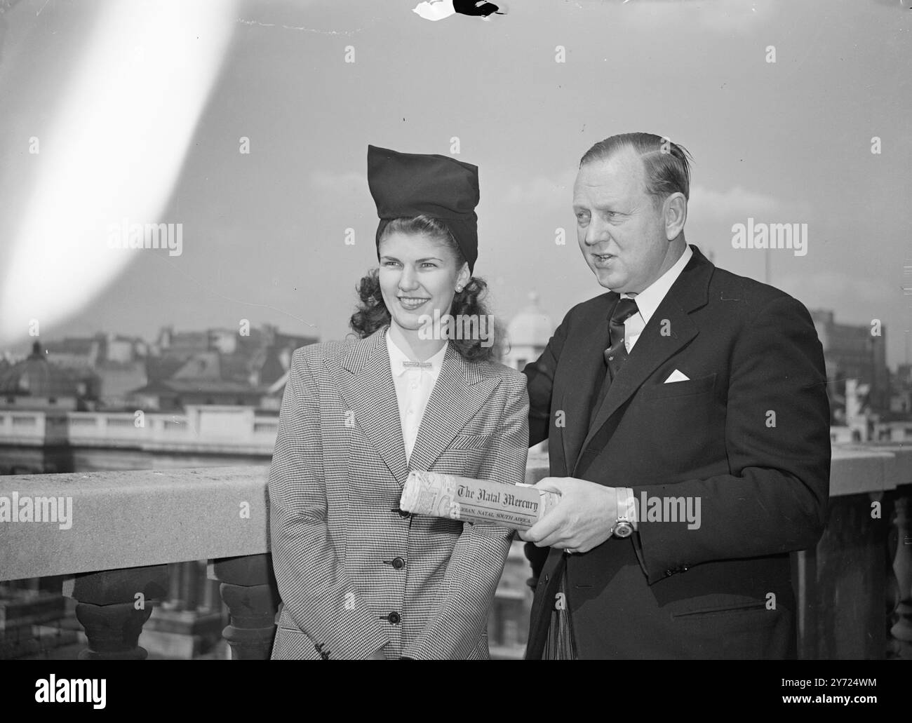 Hier, um die neuesten britischen Moden zu sammeln und sie auf ihrer Rückkehr nach Südafrika zu zeigen, ist Miss Stella Coutts „Beauty Queen of Durban“. Stella, die heute (Freitag) den South African High Commisioner im South Africa House besuchte, fungierte als ehrenamtliche Flugbegleiterin auf dem ersten Direktflug von Durban nach London mit dem Flugzeug „City of Durban“. Das Bild zeigt: „Alle Neuigkeiten von zu Hause“. Herr Leif Egeland, Hochkommissar Südafrikas, der heute Morgen (Freitag) auf dem Dach des südafrikanischen Hauses mit der "Königin von Durban" Stella Coutts abgebildet wurde. Herr Egeland hält Lokalzeitungen vom 13. April, die von MIS geliefert wurden Stockfoto