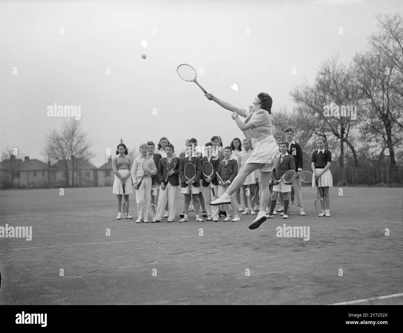 24 Jungen und Mädchen zwischen 10 und 18 haben spezielle Rasen-Tennis-Kurse im Sundridge Park Club (kent), auf Einladung des Clubs, auf einem 6jährigen Junior-Kurs. Herr J. spricht und demonstriert über die verschiedenen Schlaganfälle E Pryor, ein Kent Coach, und Mr. C. B Dniels, der Clubkapitän. Das Bild zeigt: Ann Miller-Hallett, 17, geht heute (Mittwoch) nach oben, um unter den Augen anderer Schüler im Sundridge Park einen Schuss zurückzugeben. April 1948. Stockfoto