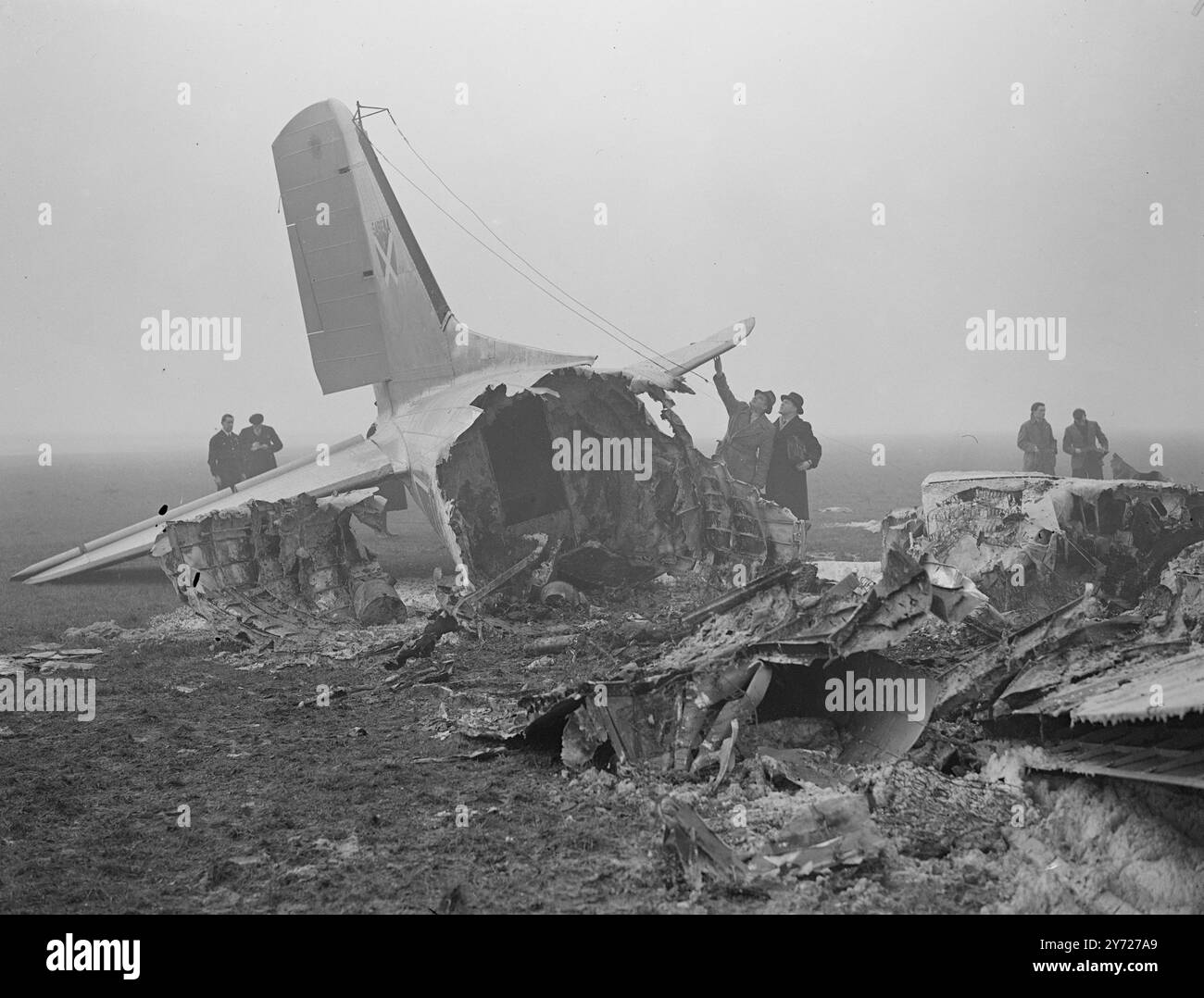 Dakota-Absturz, 19 Tote. Nur 3 der 22 Besatzer des belgischen Sabine Dakota-Flugzeugs flohen mit ihrem Leben und Flugzeug, kamen gestern Nacht in dichtem Nebel auf dem Londoner Flughafen an, schlugen den Asphalt in die Luft, fielen wieder und explodierten. Diese Flamme und das fliegende weiße heiße Metall verhinderten die Rettung von 16 Passagieren und der dreiköpfigen Besatzung. Mit Ausnahme des Schwanzes war die Time Machine vollständig ausgebrannt. Das Bild zeigt: Beamte der Unfälle Investigation Branch des Ministeriums für Zivilluftfahrt untersuchen heute (Mittwoch) die Wrackteile der Dakota am Londoner Flughafen. 3 Stockfoto