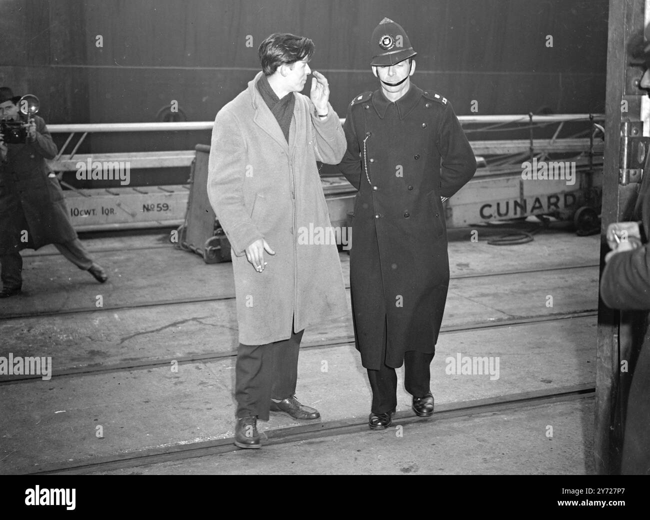 Aquitted G. Ich kehre zu U. zurück S Billy Burke Edwards, der 24-jährige G. Ich, der kürzlich in Trowbridge (Whiltshire) freigesprochen wurde, seine drei Monate alte Tochter Brenda ermordet zu haben, bin heute auf der S.S. Marine Marline mit seiner Frau und seinem zweijährigen Sohn Billy aus Southampton gefahren. Das Bild zeigt: Billy Burke Edwards, hat ein letztes Wort mit einem Polizisten, als er heute (Samstag) am 28. Februar 1948 Southampton verlässt Stockfoto