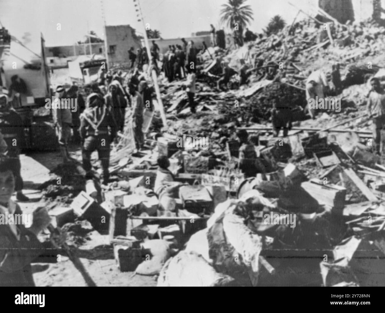 Am 11. März 1966 wurden mindestens 45 Menschen getötet und mehr als 100 verletzt, als eine Sturzflut die südliche Wüstenstadt Jordaniens praktisch auslöschte . Unser Bild zeigt Soldaten der Jordan Armee, die an Rettungseinsätzen beteiligt sind. Die jordanische Armee mit Zivilisten und US-Hilfspersonal räumten die Trümmer ab und errichteten provisorische Krankenhäuser , um Hunger und Krankheiten nach der Katastrophe zu minimieren . Dutzende Bulldozer und andere Erdbewegungsgeräte helfen Soldaten bei der Suche nach Leichen in Trümmern, die bis zu 15 Meter tief sind. 13. märz 1966 Stockfoto
