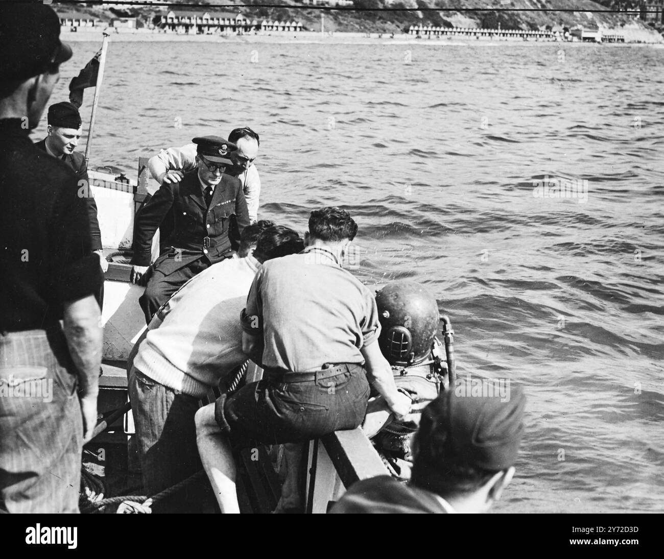 Tausende von Menschen an der Küste von Bournemouth sahen ein Spitfire, das Stunts im Zusammenhang mit einem Aufruf zur britischen Schlacht für den RAF Benevolent Fund machte, plötzlich ins Meer getaucht und verschwand. Das Flugzeug wurde von Flight Lt B.E.Green, einem Kanadier, gesteuert. Ein Funkwagen war an der Küste und die Betreiber und andere, darunter der Bürgermeister von Bournemouth, standen in Kontakt mit dem Piloten. Es war eine Antwort auf eine Anfrage im Radio, dass Flight - Lt Green seine Maschine in eine Siegerrolle setzte, die tödlich war. Das Bild zeigt: Ein Taucher steigt hinab, um das Spitfire zu lokalisieren, das in den Meeresmüll gestürzt ist Stockfoto
