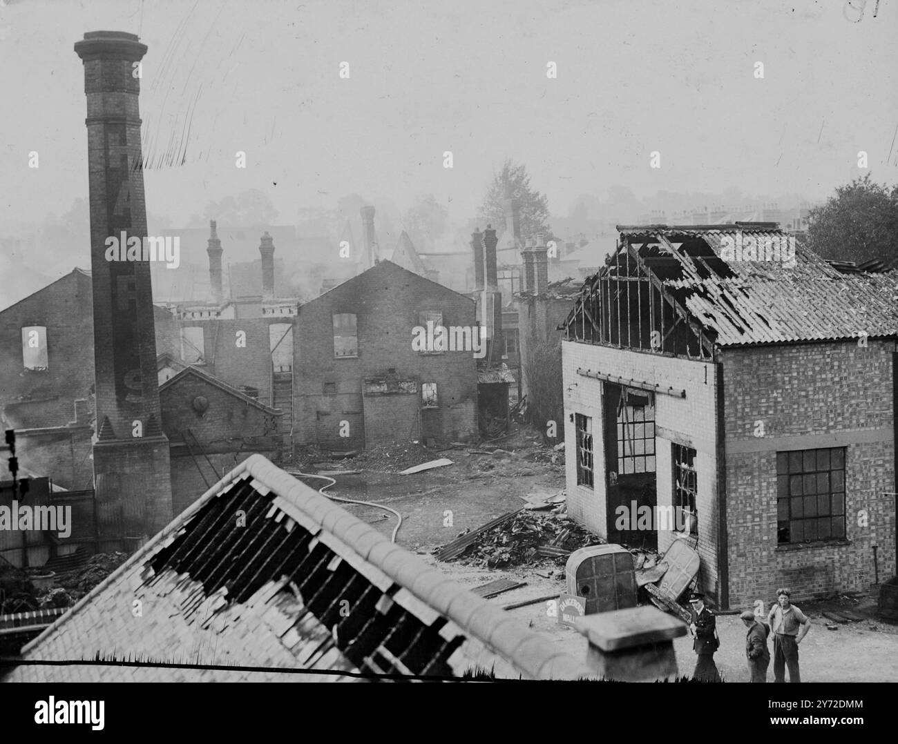 Heute Morgen wurde eine Frau getötet und mehrere Menschen verletzt, als eine kleine Zellulosefabrik, die Alfred Harris and Company Ltd gehörte, und etwa zehn Häuser in Richmond in Flammen aufging. Der Ausbruch wurde zuerst durch eine laute Explosion entdeckt und der Brand soll durch die Entzündung von Zellulose verursacht worden sein. Das Bild zeigt: Eine allgemeine Ansicht des Brandortes heute Morgen, die ausgebrannte Zellulosefabrik und die schwer beschädigten Häuser im Hintergrund in Richmond zeigt. 4. September 1947 Stockfoto