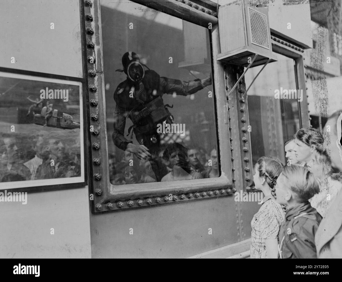 Diese Kinder, die früh auf der Engineering and Marine Exhibition, die morgen in Olympia eröffnet wird, waren mit großen Augen vor Staunen, als sie eine Demonstration von D. sahen Tag 'Froschmann' J.Daly. Daly trug einen Anzug ähnlich dem, den er trug, um Unterwasserbehinderungen am Normandie Beach Head zu beseitigen, und zeigte, wie der Anzug für den kommerziellen Gebrauch angepasst wurde. Der Anzug, der in sich geschlossen ist und viel leichter als die Standard-Tauchausrüstung ist, kann verwendet werden, um Unterwasseraktivitäten an Orten zu ermöglichen, die für den normalen Taucher nicht zugänglich sind. August 1947 Stockfoto