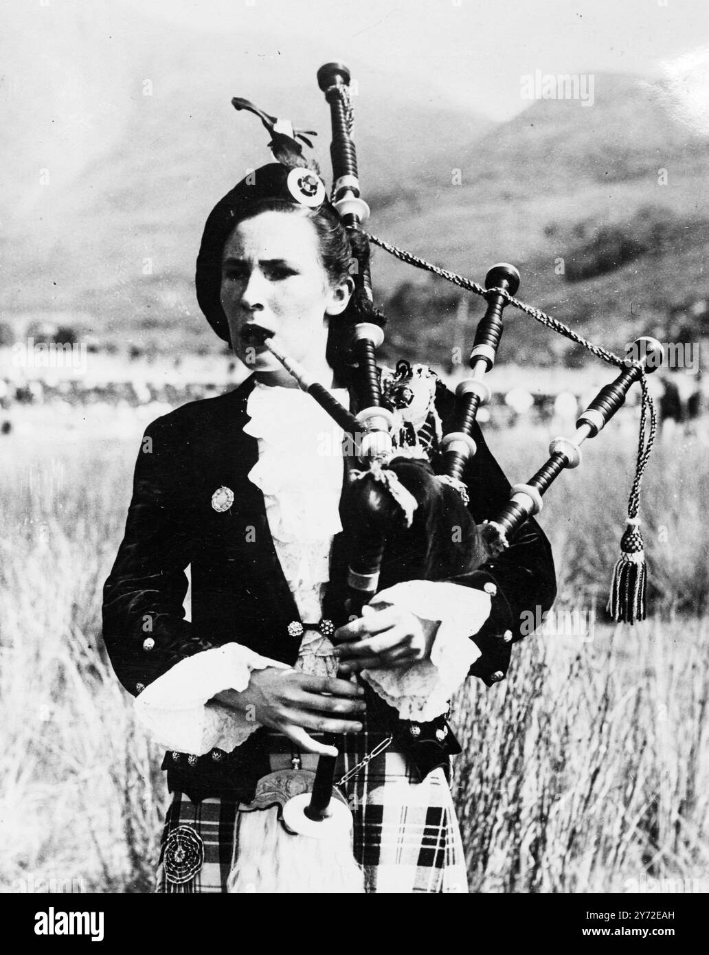 Miss Edith McPherson aus Inverness, gekleidet in das bunte Kostüm ihres Clans, macht eine attraktive Studie, die Rohre in den Marchern zu Beginn der Glenfinnan Gathering und Highland-Spiele, die jetzt in Schottland stattfinden, herausgab. August 1947 Stockfoto