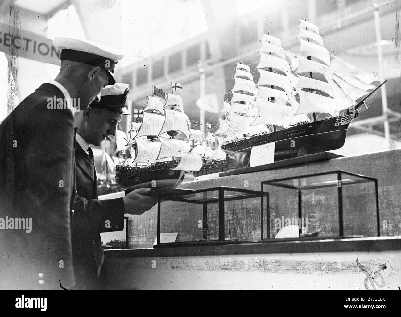 Die 22. Modellingenieurausstellung wurde heute, Mittwoch, in der Gartenbauhalle in Westminster eröffnet. Das Bild zeigt: Kontrast die Navy-Typen sind hier dargestellt als Kleinoffizier-Pilot McIntyre aus Eastleigh, Hampshire (rechts) und Kleinoffizier-Luftwaffenschützer Brown aus London, beide aus der Flottenluftwaffe, bewundern Sie einige der alten Segelschiffe bei der heutigen Ausstellung. 20. August 1947 Stockfoto