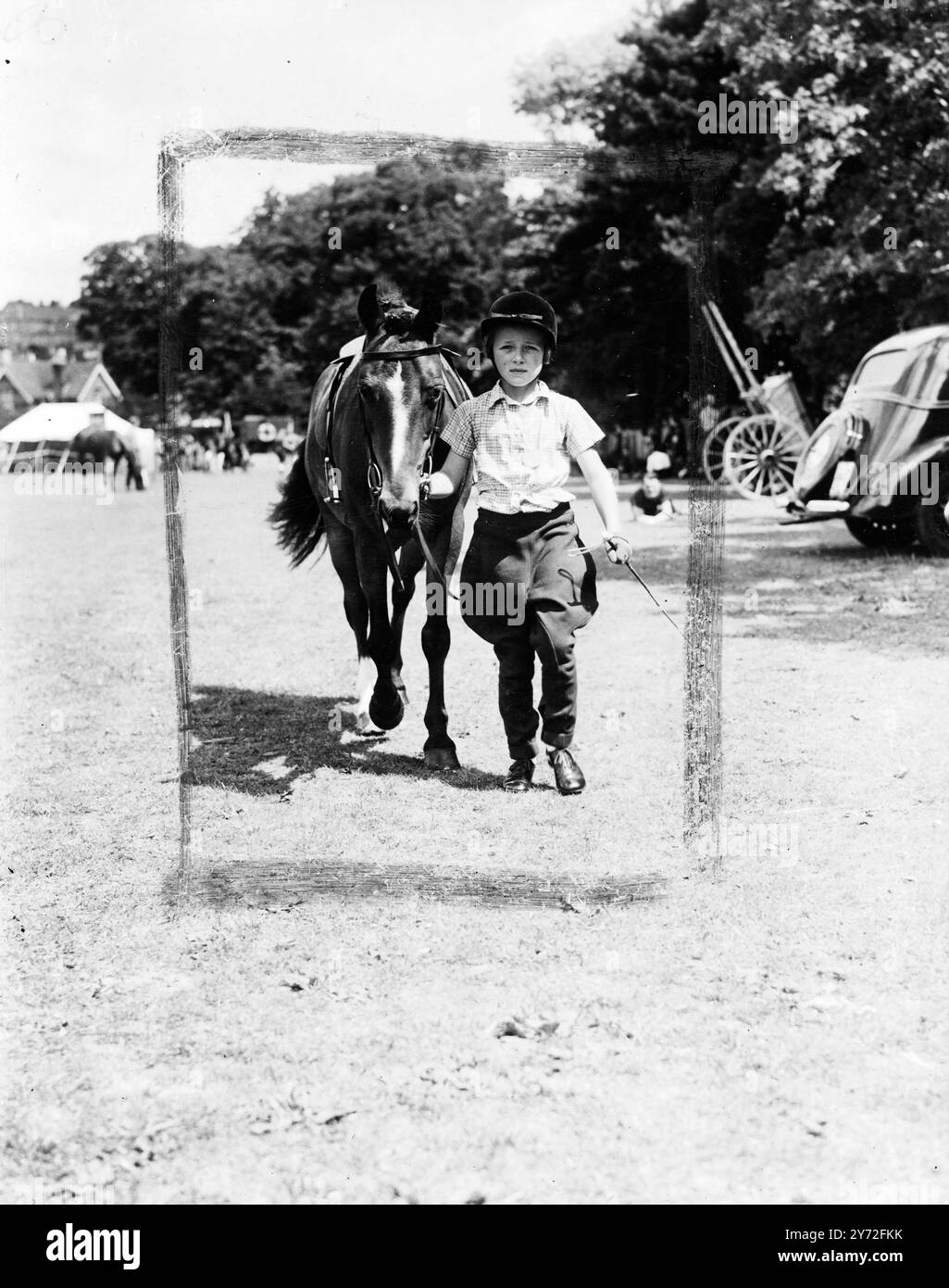 Am zweiten Tag in Folge fand die Aldershot Horse Show bei herrlichem Sommerwetter statt und zog eine große Menschenmenge an, um einige der besten Pferde des Landes zu beobachten, die in den verschiedenen Klassen antraten. Die Fotos zeigen: Miss Sarah Luard, 6 Jahre alt, von Aldershot, jüngster Konkurrent in der Kinder-Pony-Klasse, machte diese charmante Studie, als sie ihre Ponystute Tabitha Twitchet in der heutigen Show führte. 26. Juli 1947 Stockfoto