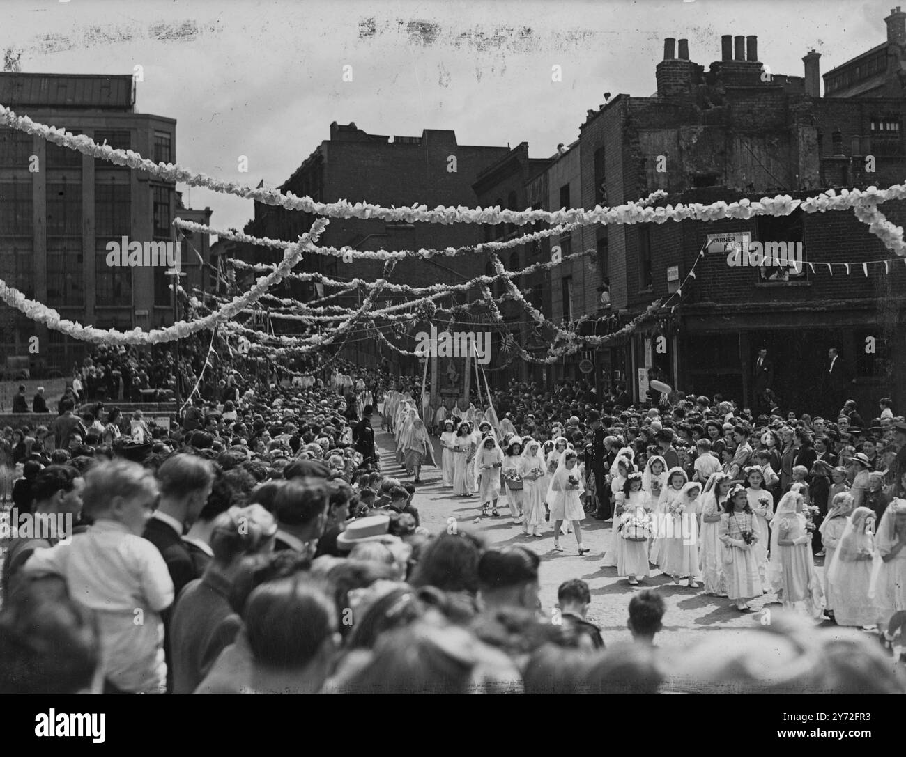 Londons „Little Italy“ hielt heute, am Sonntag, seine jährliche religiöse Prozession ab, als die meilenlange Cordage, die von der italienischen Kirche St. Peter begann, entlang der Clerkenwell Road, der Farringdon Road und des Hatton Garden in den benachbarten Straßen verlief. Bei der Prozession wurden die Fahndungen nach St. Lucia, St. Antonius und der Jungfrau durchgeführt. - 20. Juli 1947 Stockfoto