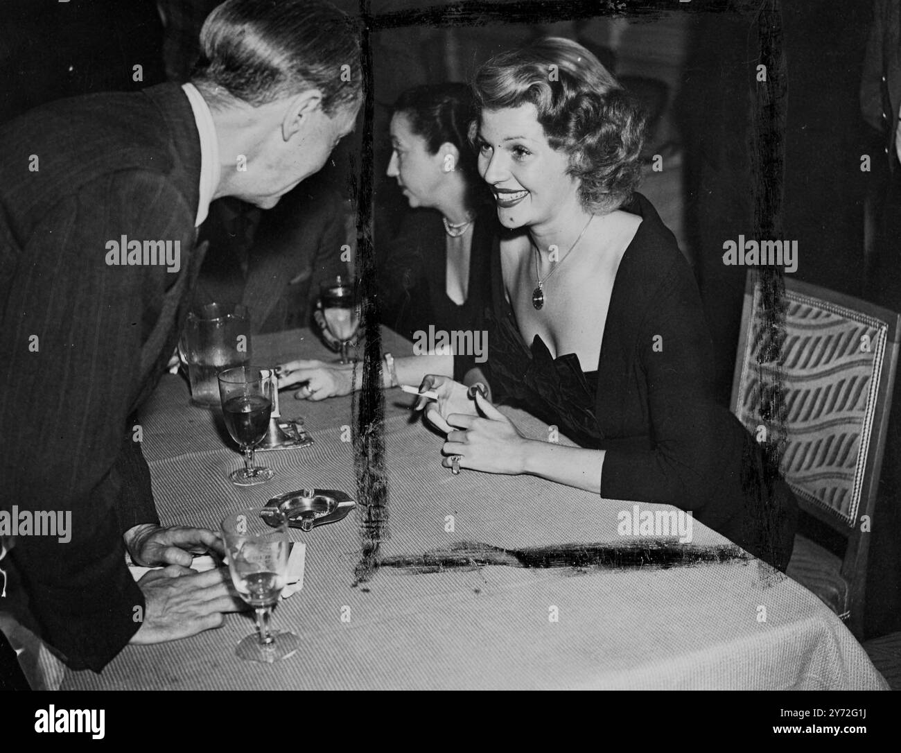 Columbia-Star Miss Rita Hayworth, bei einem Presseempfang im Savoy Hotel lächelnd neben ihrer Freundin Mrs. Lola Leighter. Sie ist auf einem 10-tägigen Besuch, wo sie einen persönlichen Auftritt im Gaumont Cinema, West End, für die Premiere ihres Films „Down to Earth“ macht. 17. Juli 1947 Stockfoto