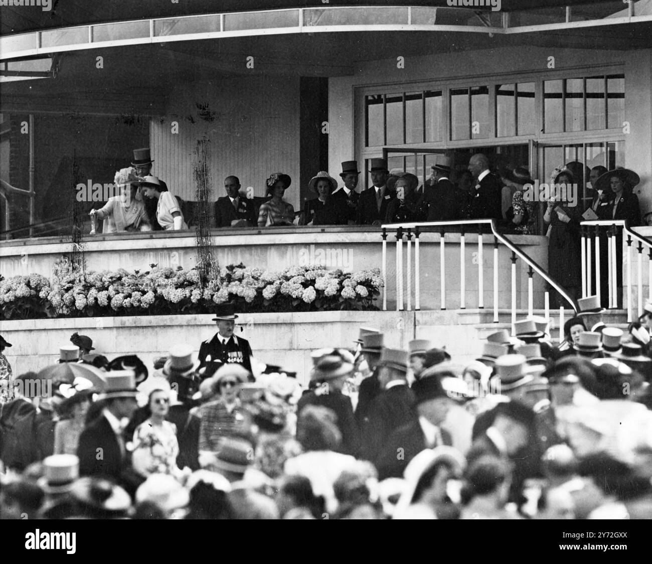 Der erste Tag der Royal Escort heute, in passender Sommersonne, zeigte eine erhebliche Verringerung der Sparpolitik, die seit den Vorkriegsjahren vorherrschte. Formelle Fuchs, typische ascot-Hüte und Morgenkleider waren die Regel für diesen unvergleichlichen sportlichen und gesellschaftlichen Anlass im königlichen Gehege. Das Treffen wurde mit einer Staatsfahrt durch den Hof durch die königliche Familie eröffnet, die für das Rennen aus Windsor gekommen war. Bei den meisten Rennen, die für das viertägige Treffen geplant sind, einschließlich der heutigen Goldbarren und ascot Stakes, werden hausgemachte Pferde starke Widerstände von vielen Einsendungen aus Frankreich finden. Bild Stockfoto