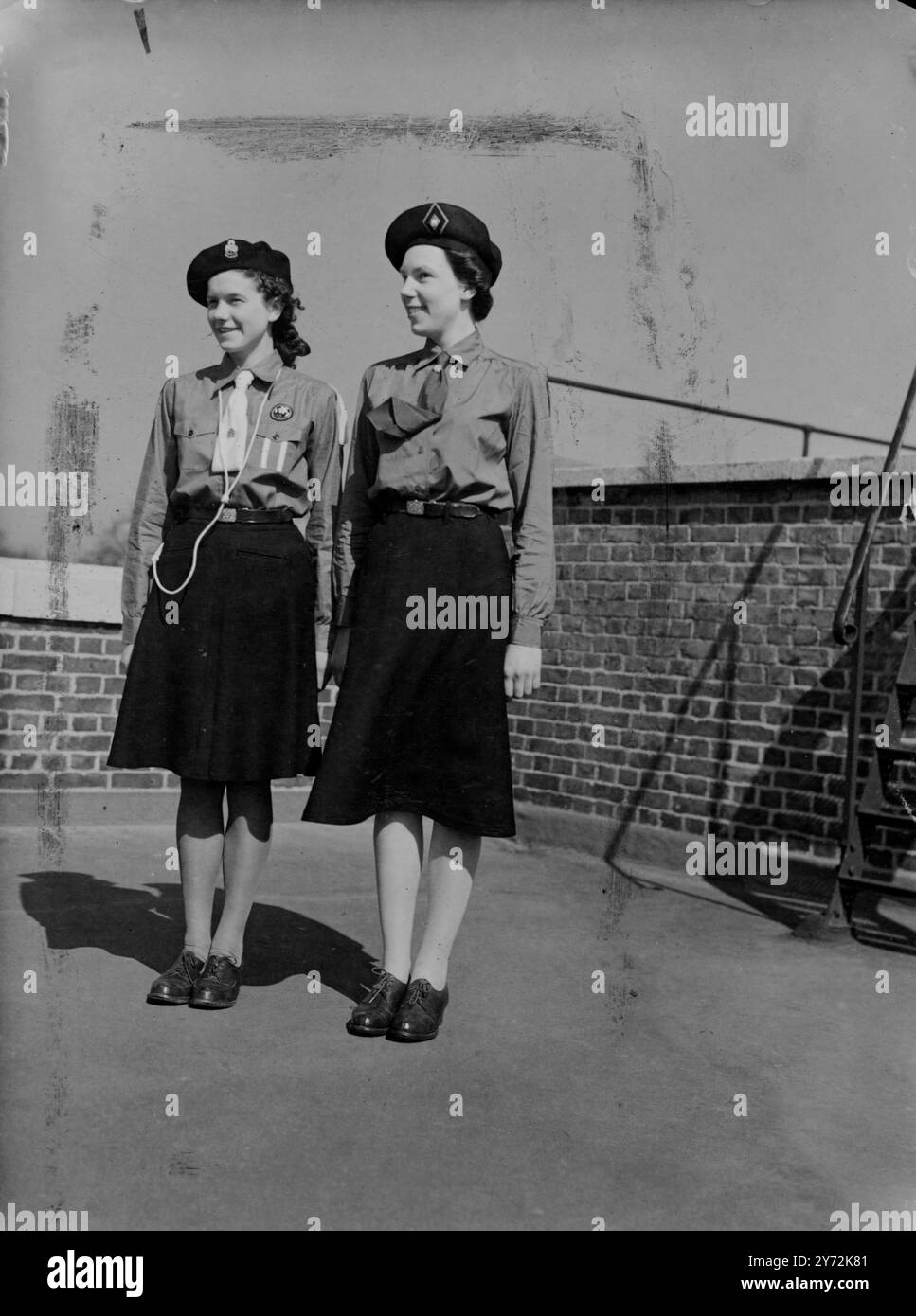 Die neuen Uniformen, die Mädchen und Führerinnen ausstatten sollen, wurden heute erstmals in London gezeigt. Die Uniform des Guides besteht aus einer hellblauen Bluse, einem marineblauen Rock und einer Baskenmütze. Ein hellblaues Kleid als alternative Uniform ist so bald wie möglich bereitzustellen. Für Führer (Erwachsene Führer) soll eine ähnliche Uniform eingeführt werden, und als vorübergehende Maßnahme können Führer auch ein weißes Hemd mit marineblauem Rock und marineblauer Kampfbluse tragen. Aufgrund der akuten Materialknappheit für die neue Uniform wird die Rate, zu der sie den Mitgliedern der Mo geliefert werden können, strikt begrenzt Stockfoto
