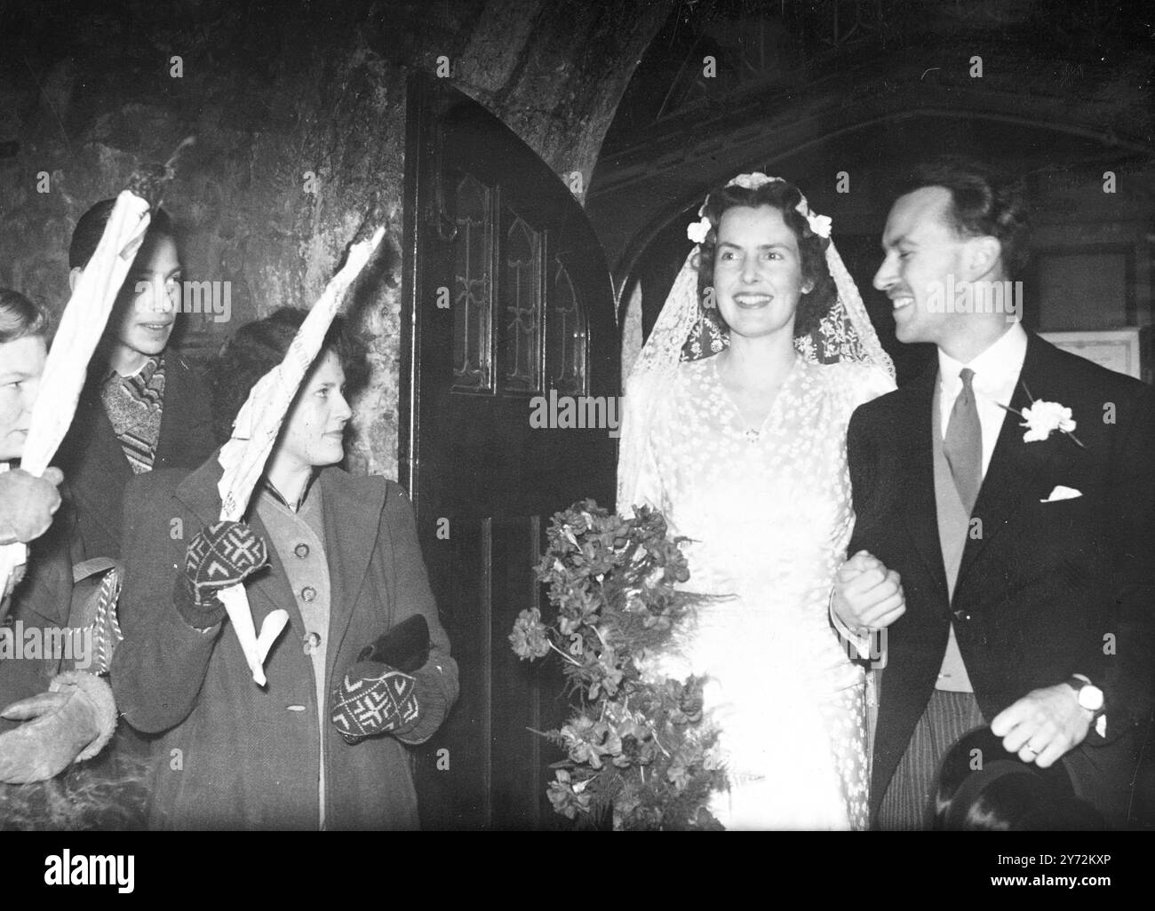 Niederländische Schweizer Hochzeit im Londoner Nebel. Herr Jan Doorn, ältester Sohn des niederländischen Generalkonsul in Prag, war heute Montag mit Miss Margery (Poppy) Petrie aus Les Avants, Schweiz, verheiratet. Die Heirat fand in der St Ethelburga’s Church in London statt. Die Fotos zeigen, dass Braut und Bräutigam die Kirche nach der Zeremonie verließen, Papierfackeln gehalten wurden, um ihren Weg zu beleuchten. 21. Januar 1946 Stockfoto