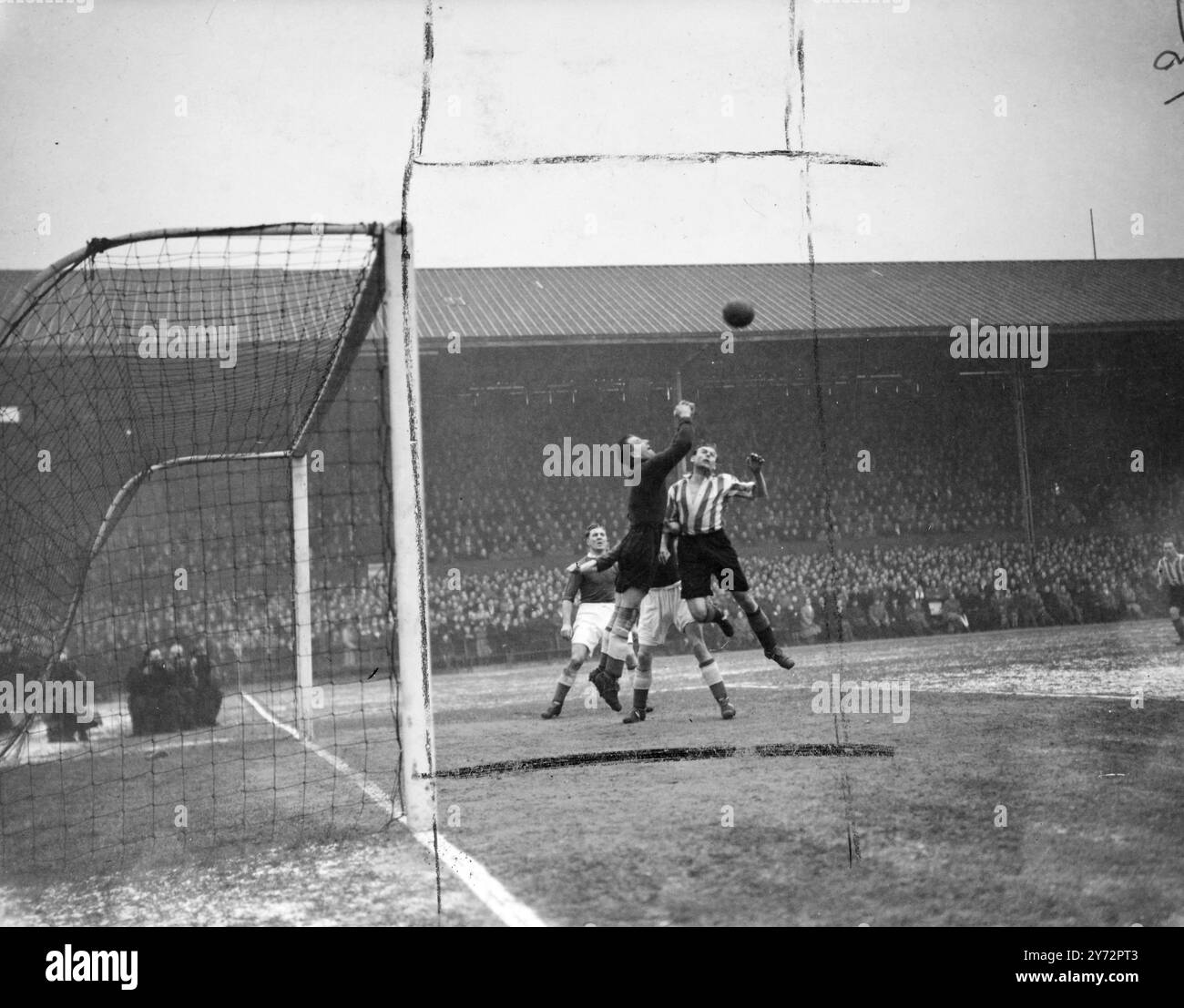 Brentford gegen Leicester City. Brentford traf heute, Samstag, in der vierten Runde des FA Cups in Brentford auf Leicester City. Foto zeigt Joe Calvert, der Torwart von Leicester, der während des heutigen Spiels unter einer Menge von Stürmern aus Brentford den Ball freischlägt. 25. Januar 1947 Stockfoto
