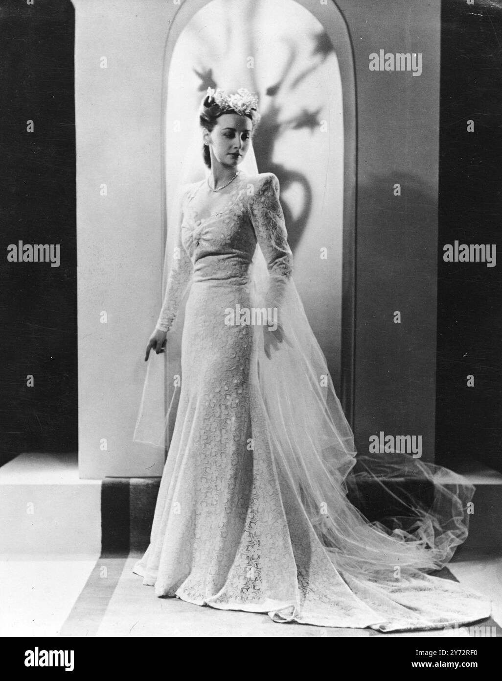 Ein wunderschönes Hochzeitskleid, das speziell von Miss Wallace von Maude Knott entworfen wurde, um in die Wollkollektion aufgenommen zu werden, die die International Wool Secretariats an das australische Wollbrett geschickt haben. Er ist in klassischen Linien geschnitten und hat einen schmeichelnden, aber herzförmigen Ausschnitt. Er ist mit feinstem Wandbereich gefertigt und umhüllt den Faden aus silbernem Lametta. 6. Januar 1947 Stockfoto